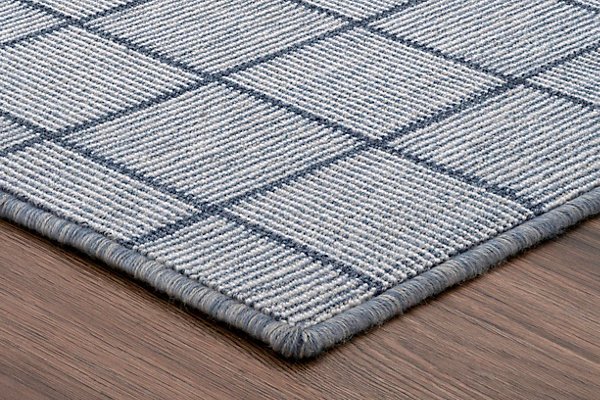 Close-up of a blue and gray striped area rug on hardwood floor.