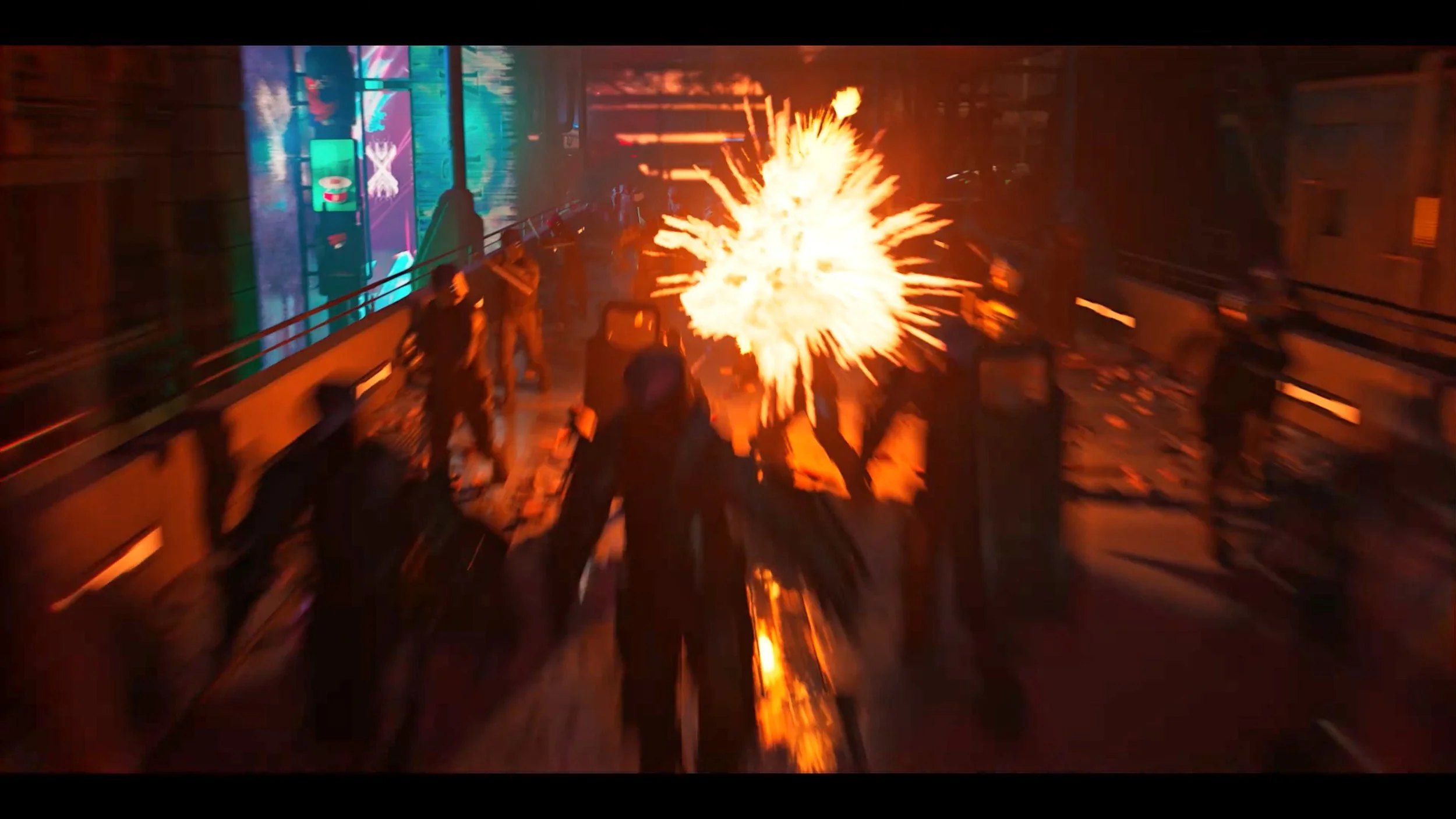 Scene from the movie 'Blade Runner 2049' featuring a group of people on a futuristic city street fighting off a fiery explosion.