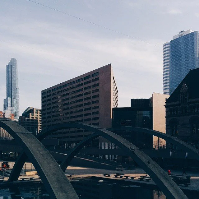 Cityscape with modern buildings, bridges, and a clear sky.