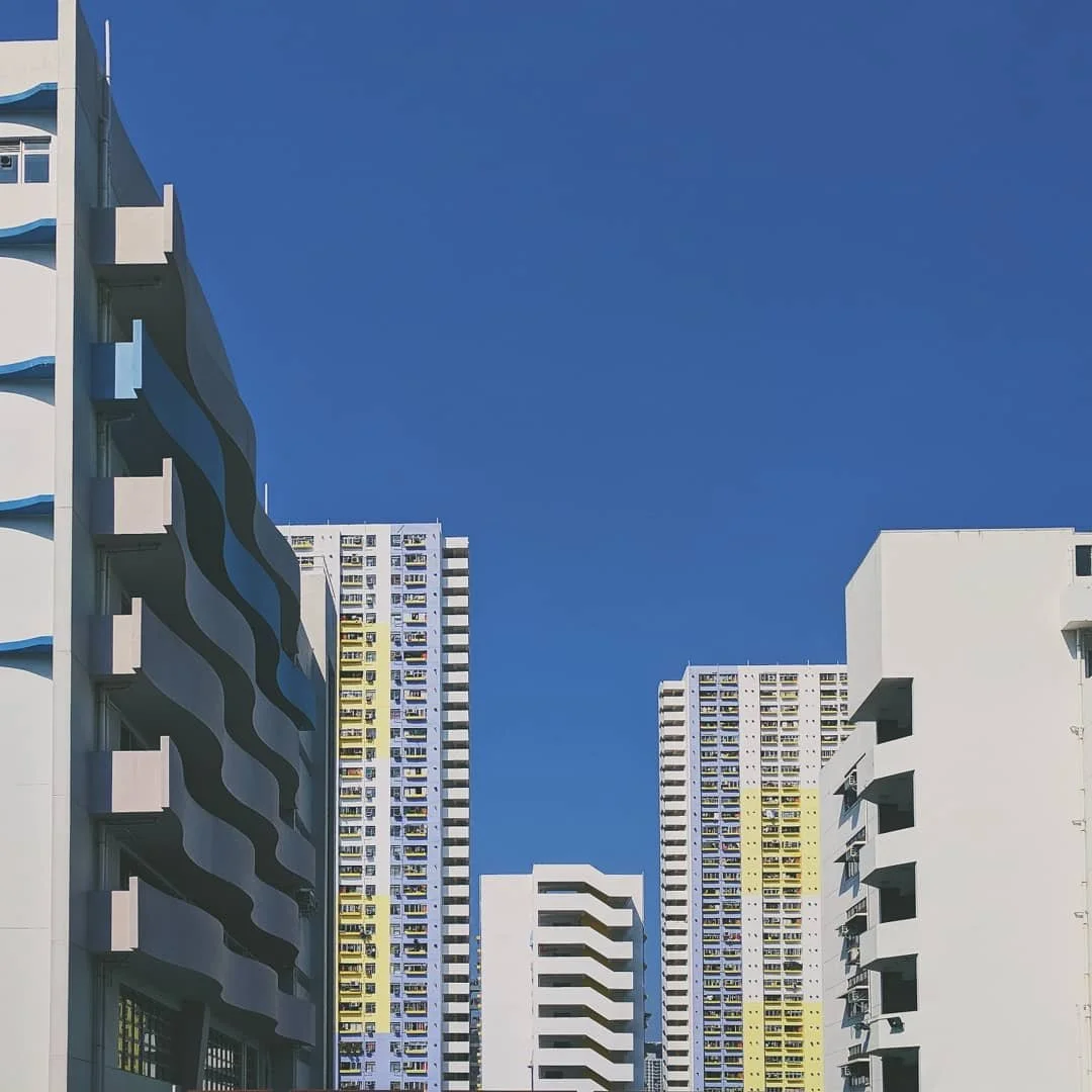 High-rise apartment buildings with modern designs against a clear blue sky.
