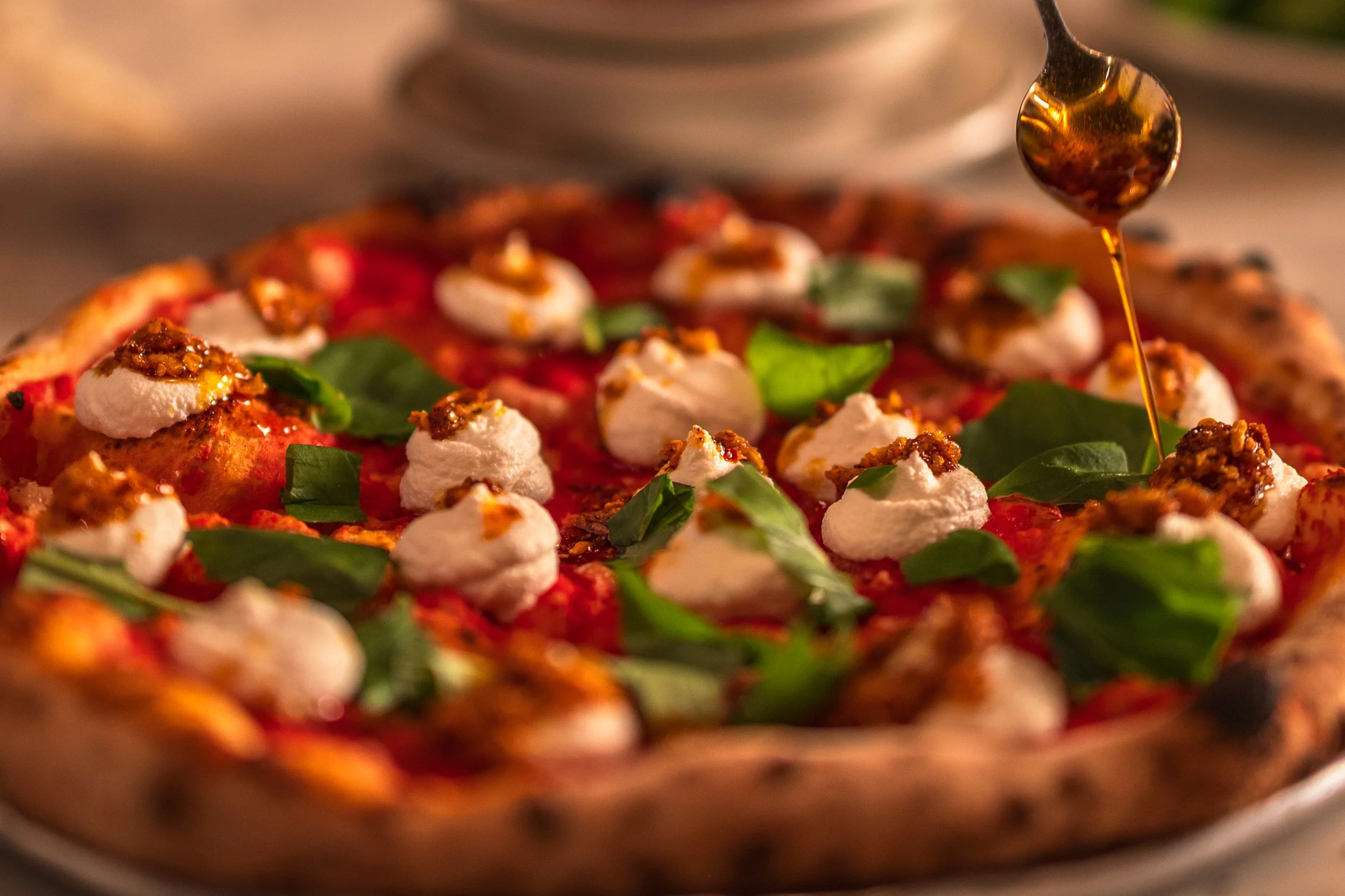 The Achilles Heat Pie x Paulie Gee's: Double sauce and garlic, ricotta, pecorino, fresh basil, Primis extra virgin olive oil, and generously dizzled with Achilles Heat smoked chili crisp.  (Photo by Chris Egan)