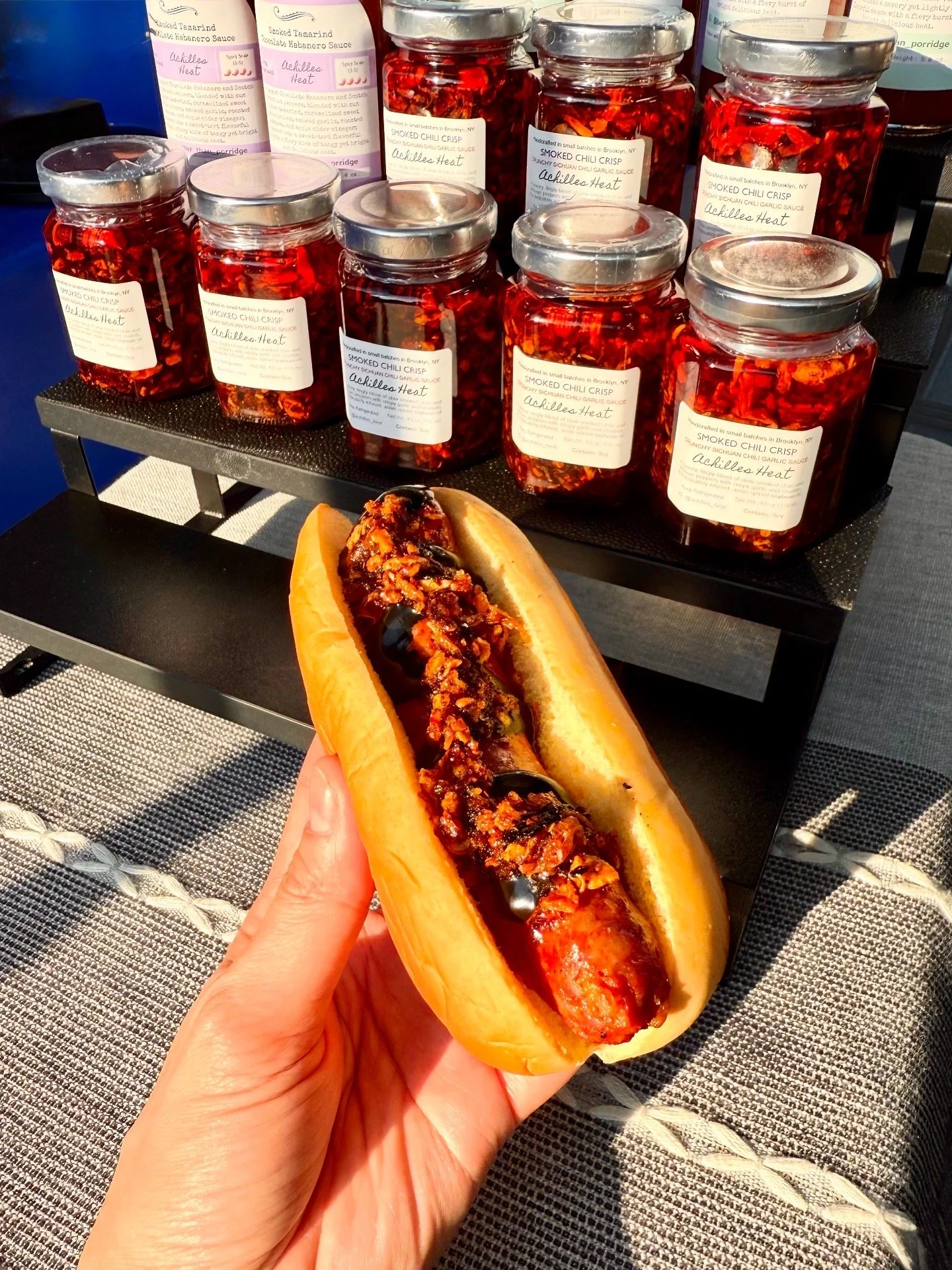 Arroces NYC × Achilles Heat® teamed up with Chef Eduardo Cuenca for the “Spanish Glizzy,” featuring juicy snappy txistorra, black garlic aioli, and Achilles Heat® Smoked Chili Crisp with our signature crispy garlic and shallots for texture and smoky 