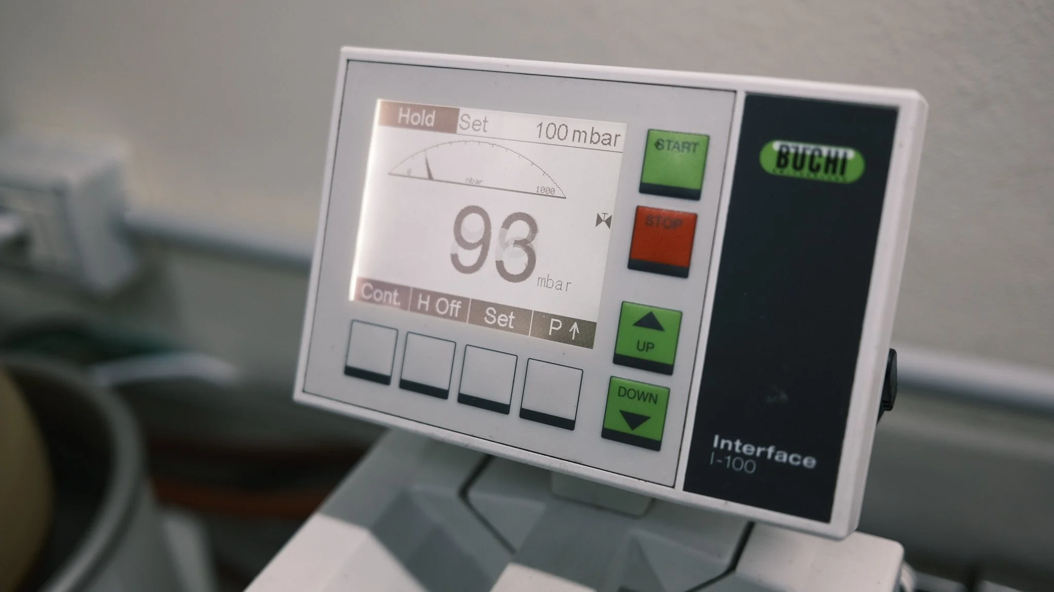 Digital display of a medical or industrial control device showing a pressure reading of 93 mbar with a gauge indicator and buttons labeled start, stop, up, and down.