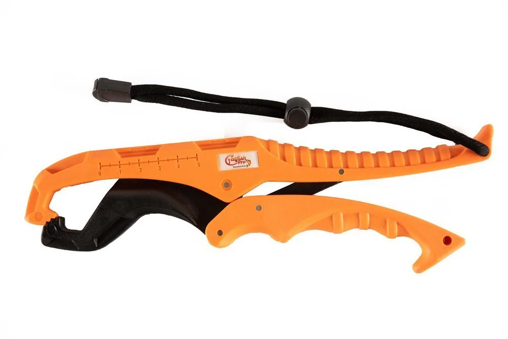 Orange and black plastic device with a strap, designed for cutting or slicing, with measurement markings on the side.