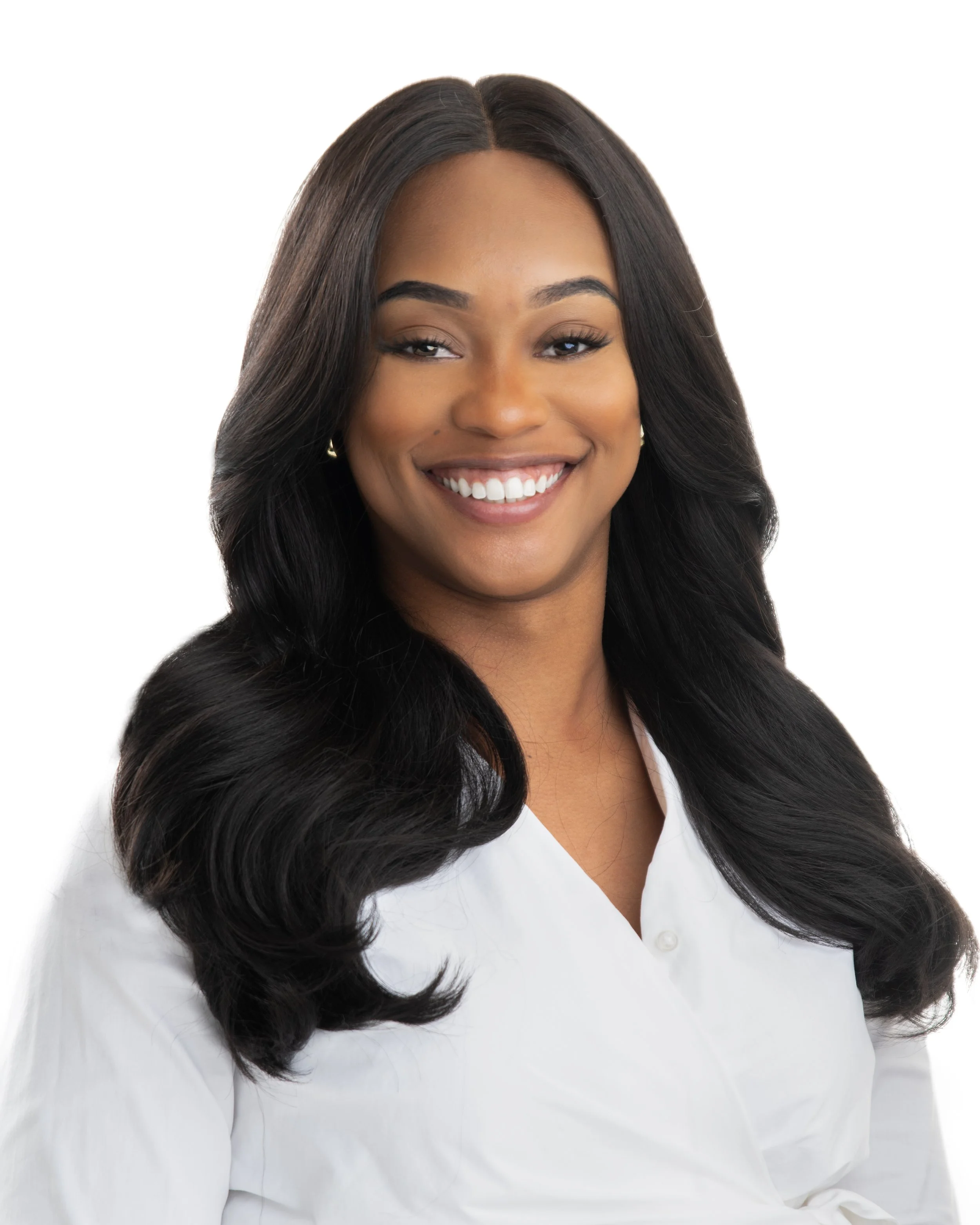 Portrait of a smiling woman with long, wavy black hair wearing a white blouse against a white background. Headshot of Shar'Mayne Mack CEO of Cleanpro and Bread and Butter.
