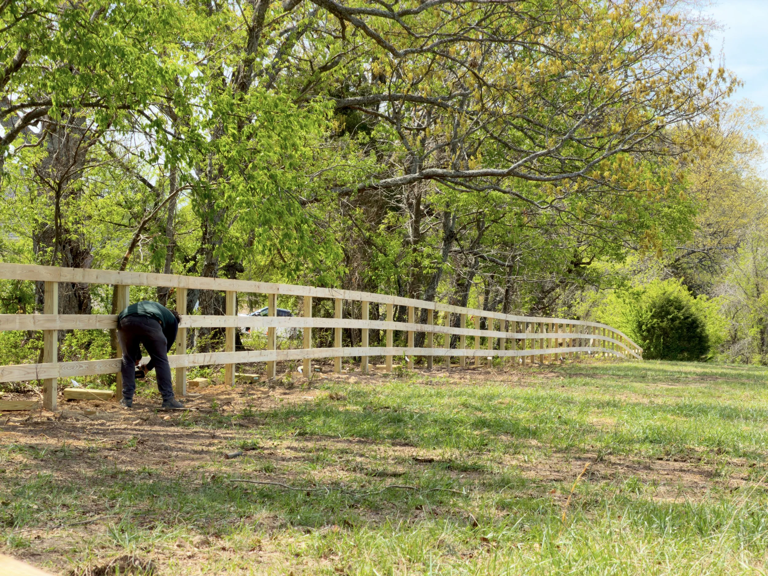 CraftBuilt installer building a pressure-treated pine rail fence in Northeast Fayetteville