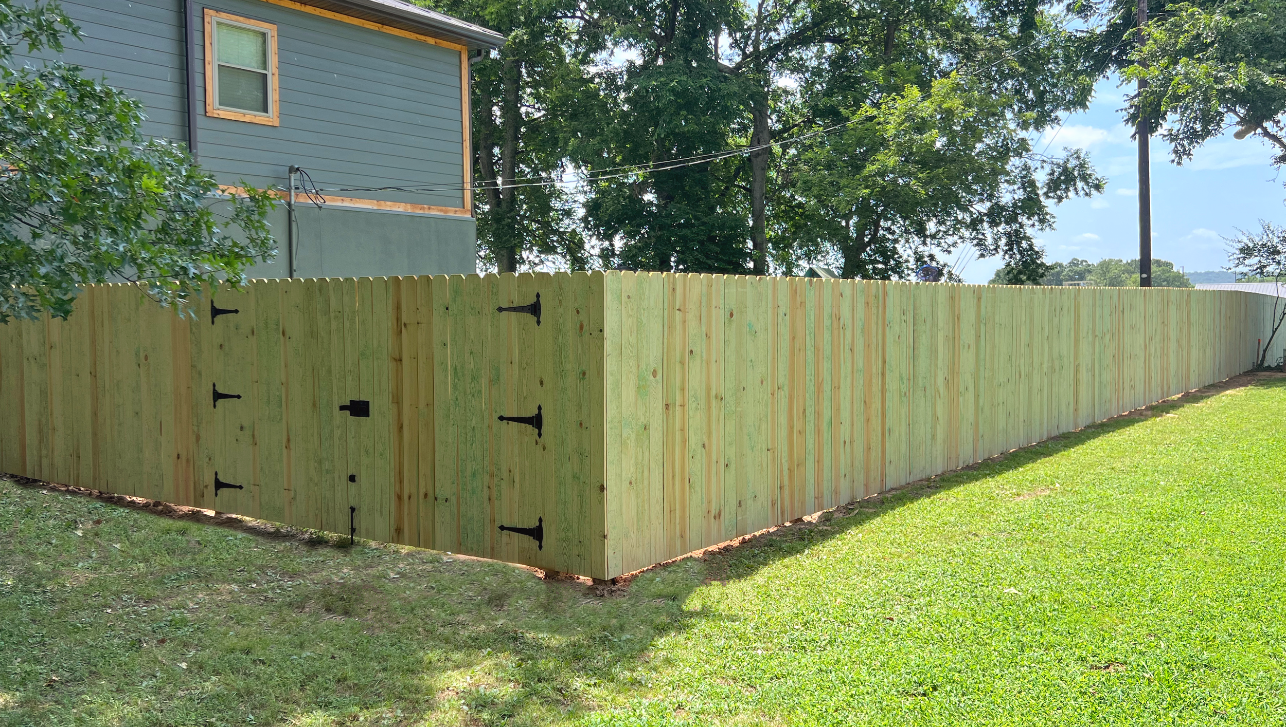 A new wooden fence with black hardware, 6 foot wooden privacy fence, pine, durable materials, straight lines