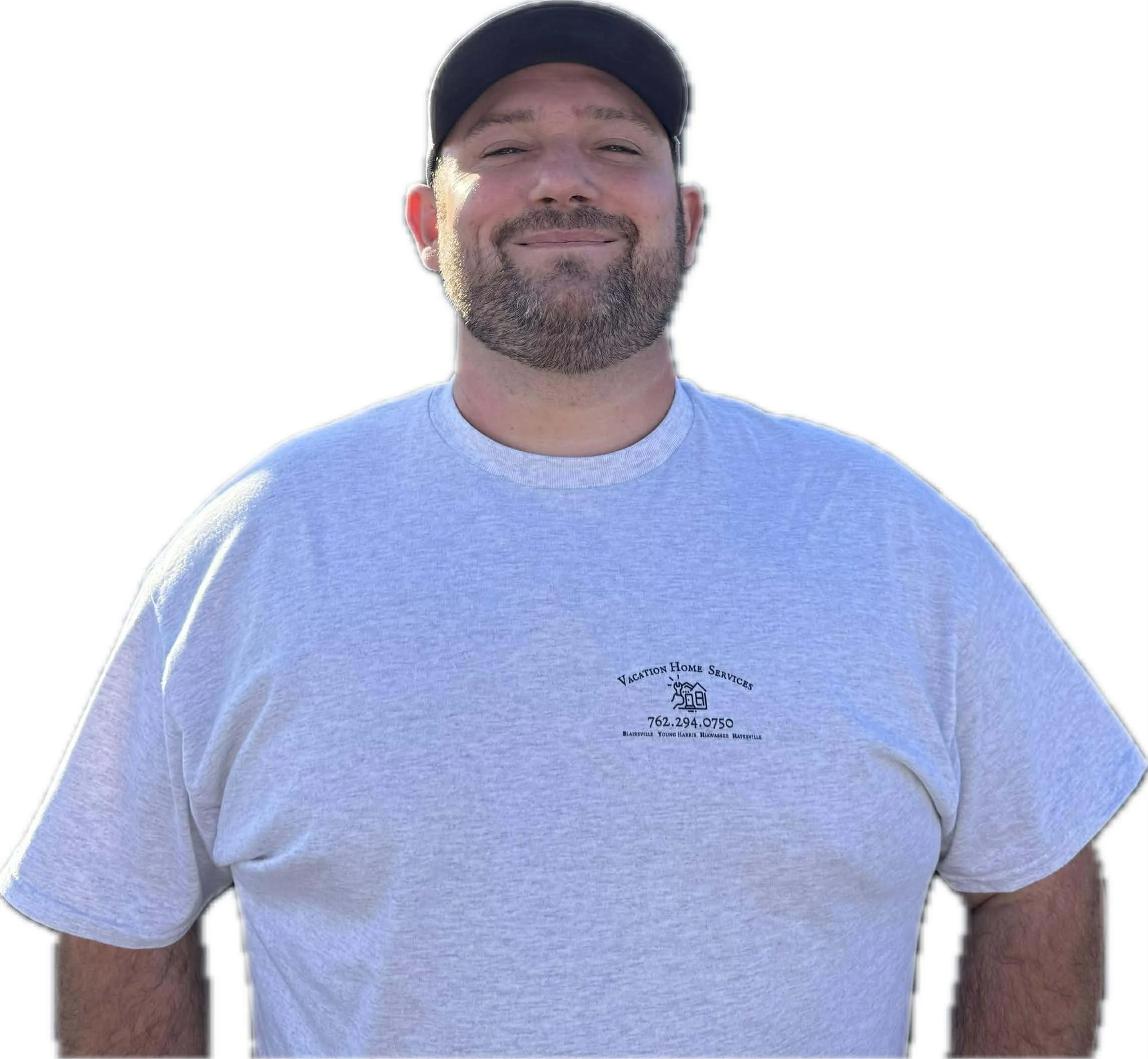Matt Smith wearing a gray T-shirt with the logo of Vacation Home Services and a black cap, standing outdoors.