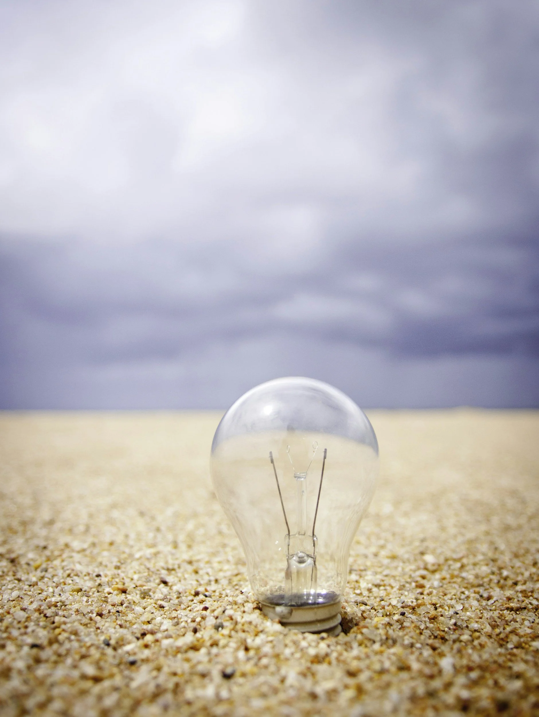 Light bulb standing in sand