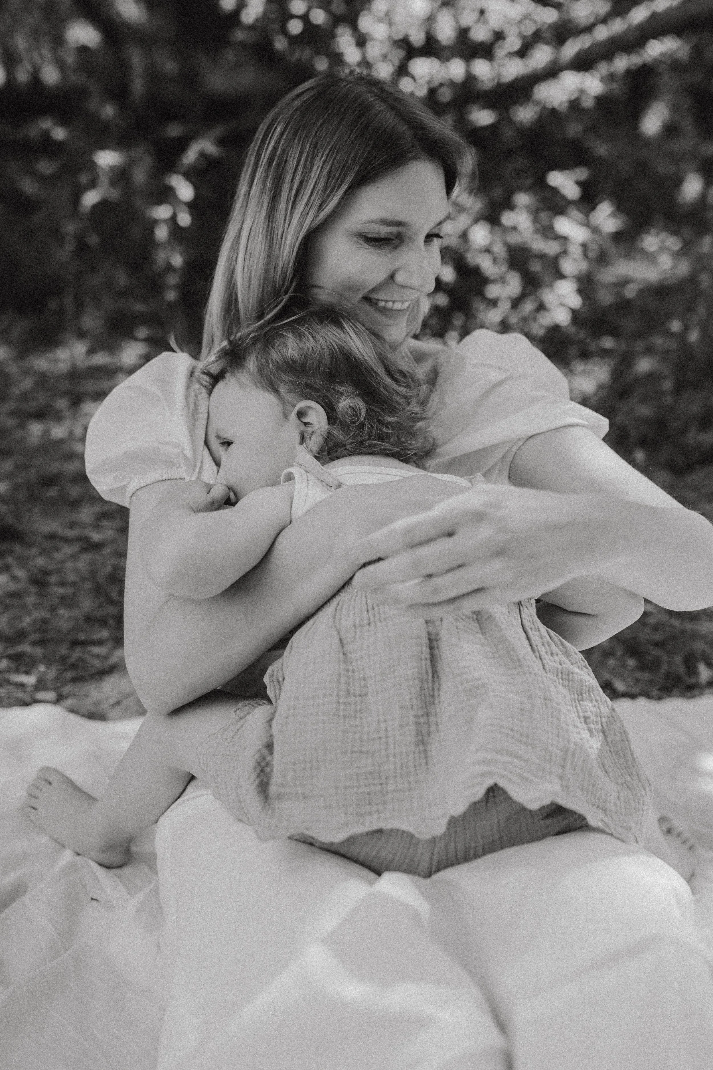 Frau und kleines Mädchen umarmen sich draußen in der Natur, schwarz-weiße Aufnahme.Mutter & Kind Shooting im Saarland, Familienshooting im Saarland, Familienfotografin. Fotografie für Mütter und Kinder.