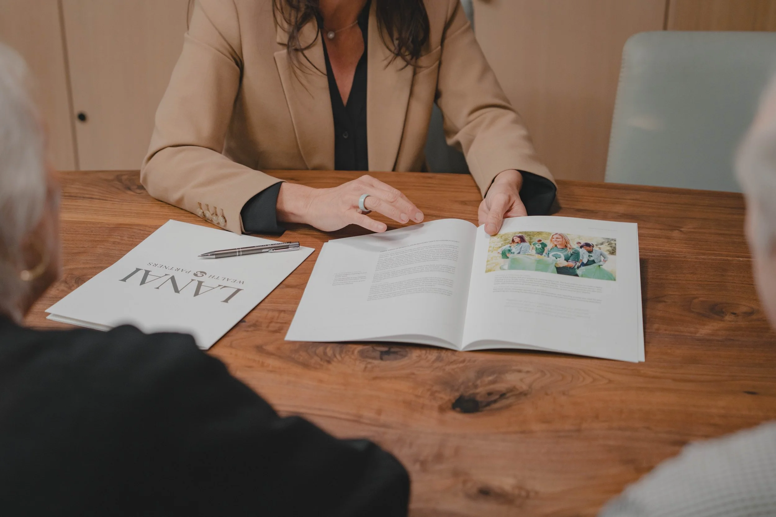 A woman showing their client a book of financial options.