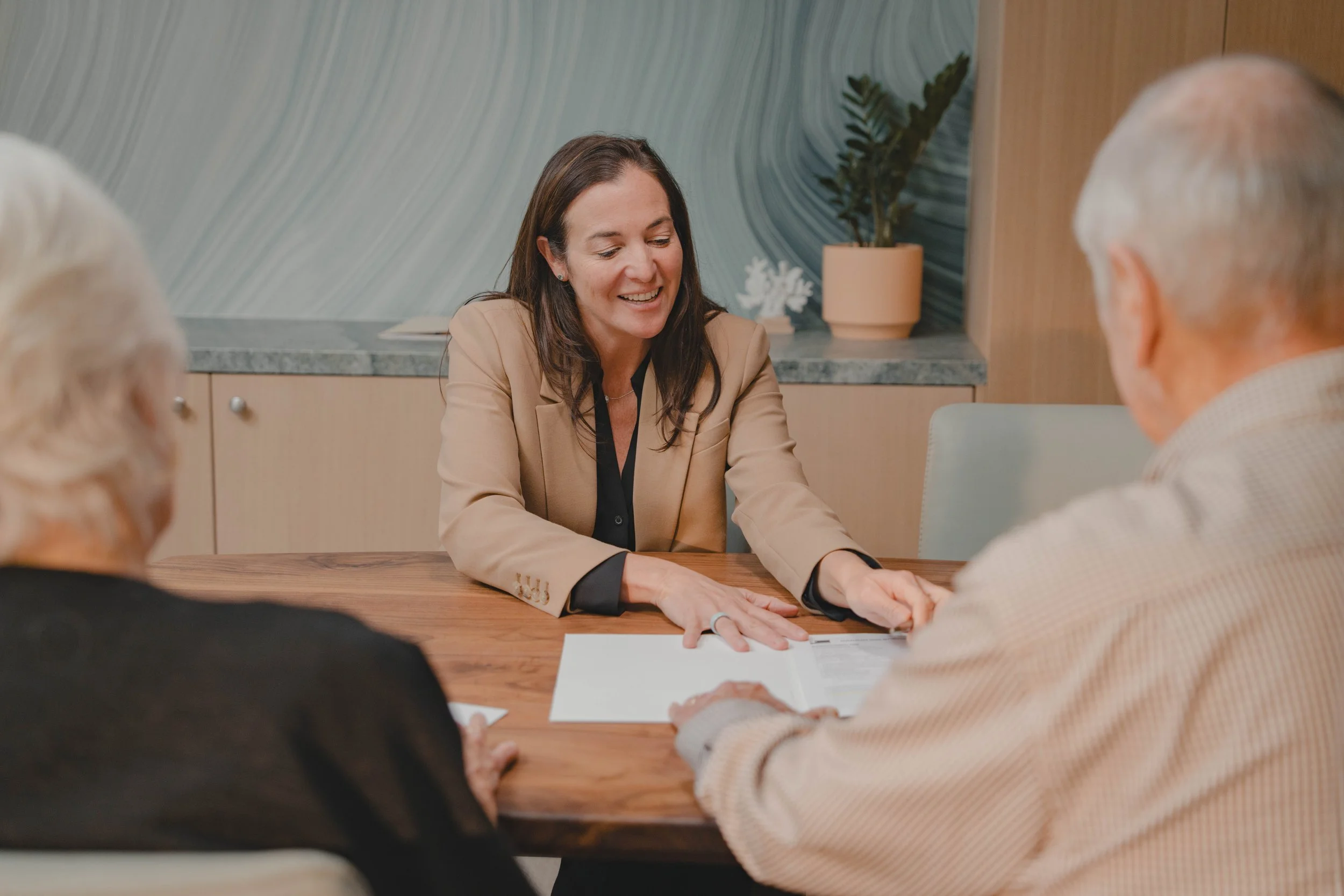 Christine, Founder & President, talking to an older couple about financial solutions.