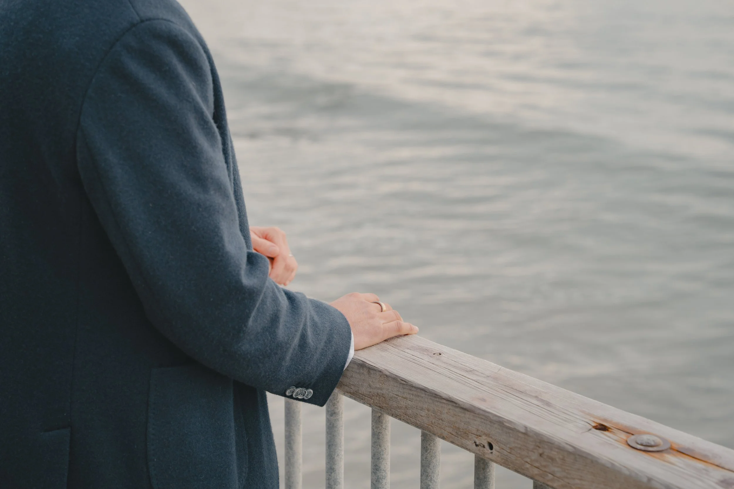 A person overlooking the ocean at Capitola Village at the guard rail.