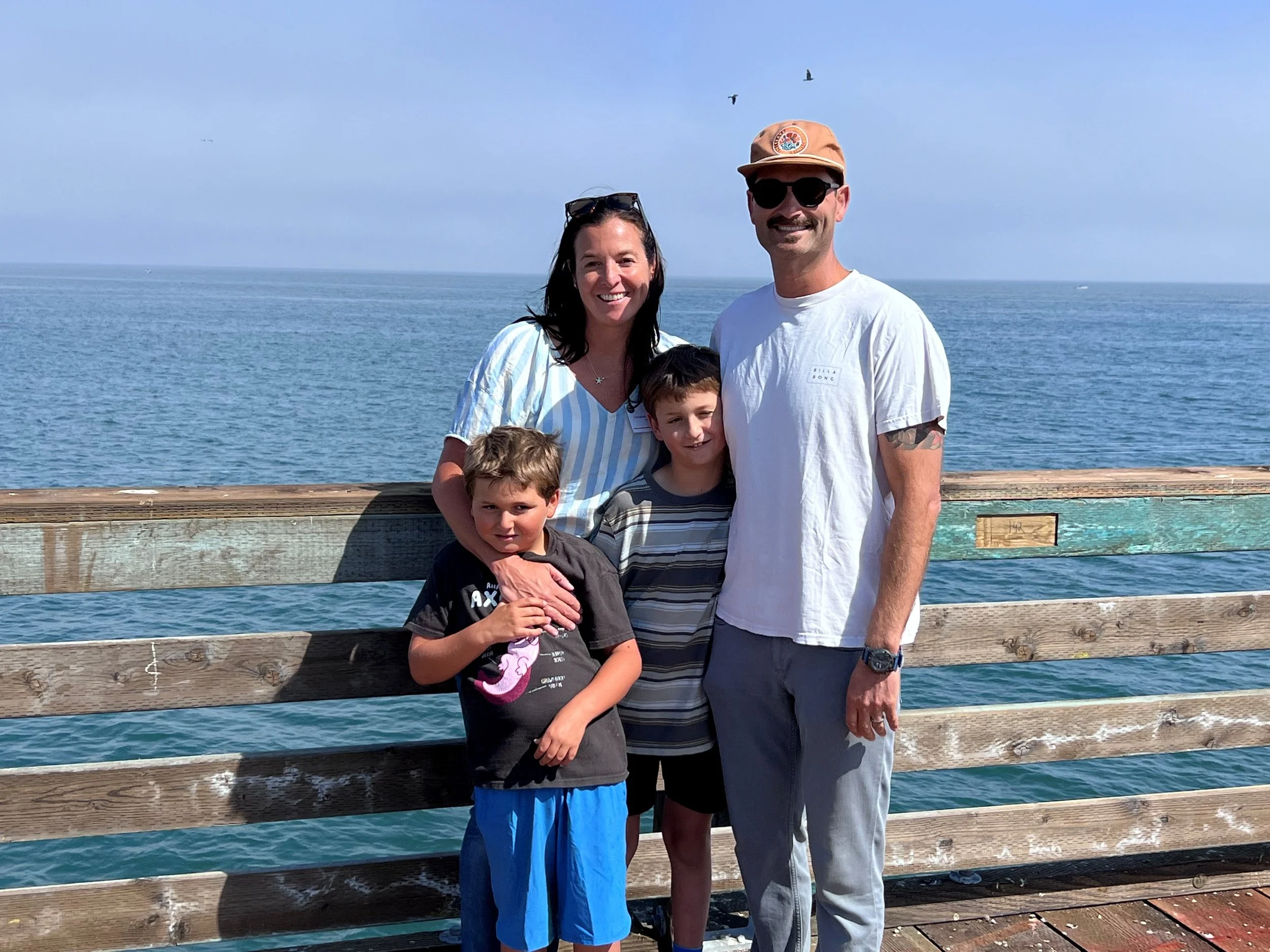 Christine and her family taking a photo on the Capitola Wharf.