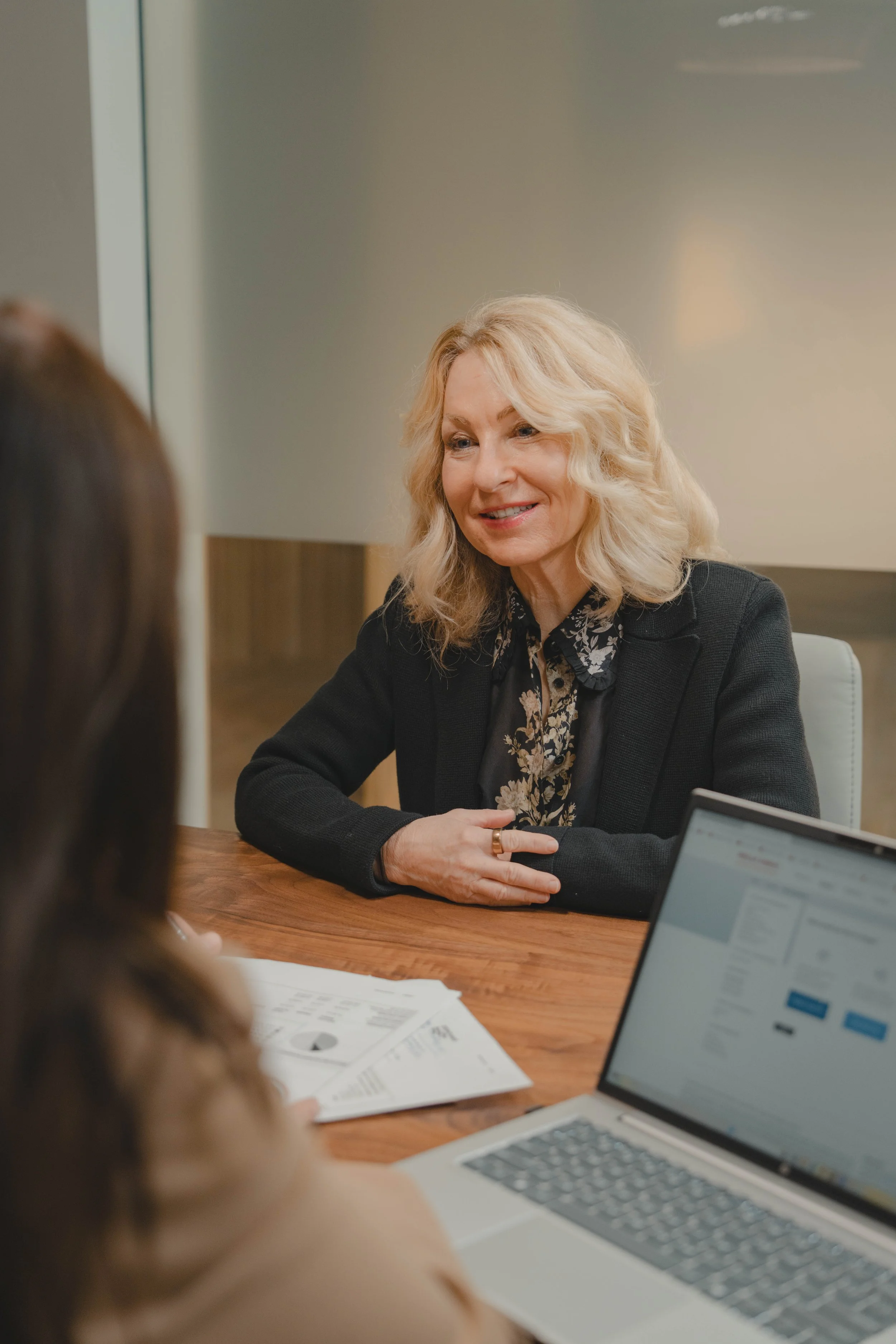 A women with a caption and papers helping a client with financial solutions.