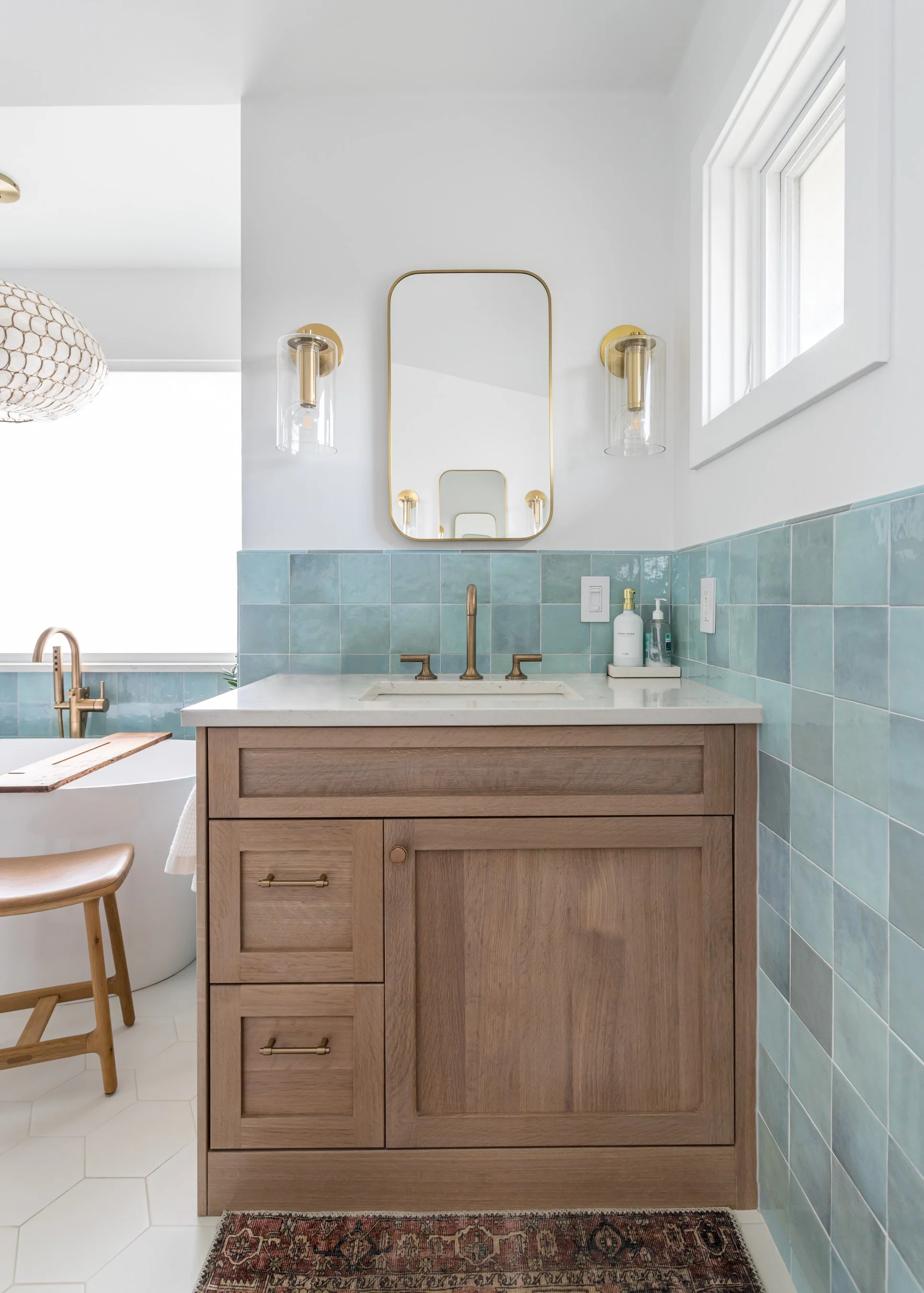 This vanity brings the calm: soft natural wood tones meet sea-glass blue tile for a finish that’s as fresh as it is functional.