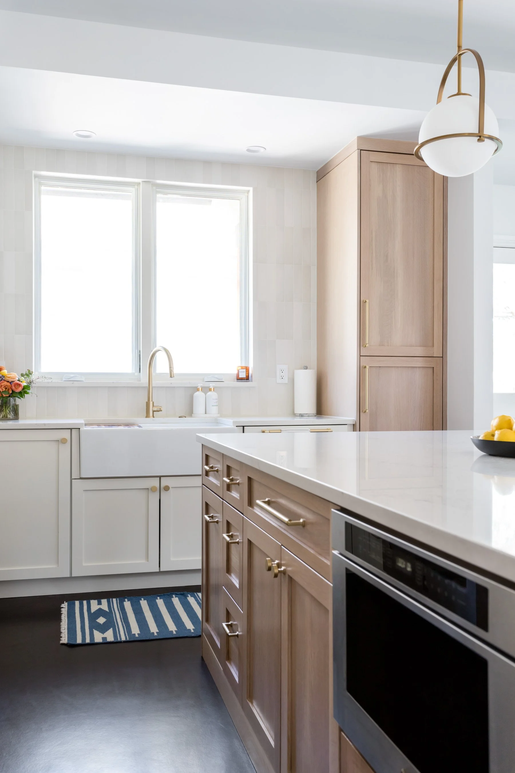 From this angle, it’s all about function-meets-flair: a deep farmhouse sink for soaking everything (even the dog bowls), and a discreet microwave drawer that keeps the countertops clean and conversation flowing.