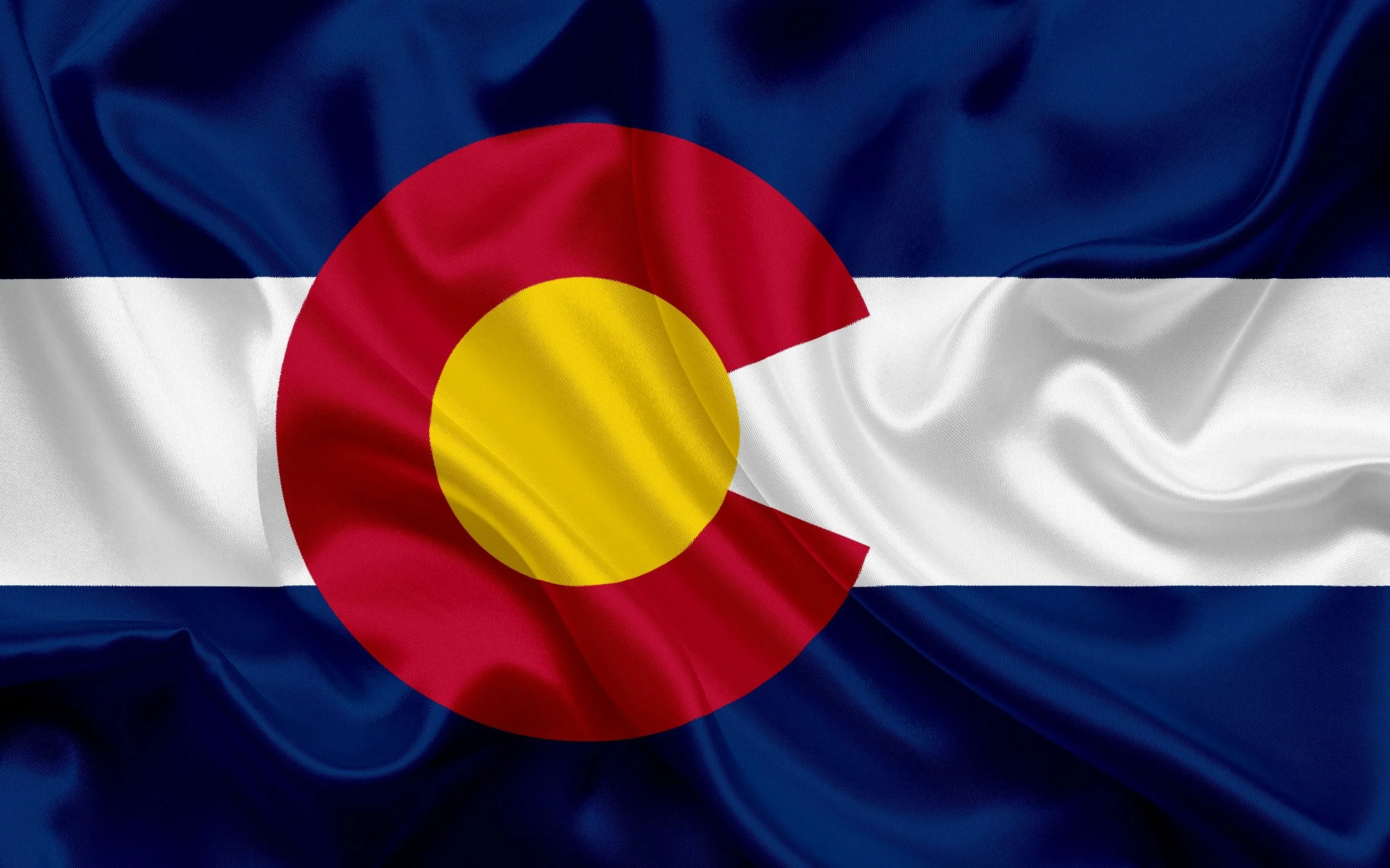 Folding Colorado state flag with blue, white, and red horizontal stripes and a red 'C' with a yellow center.