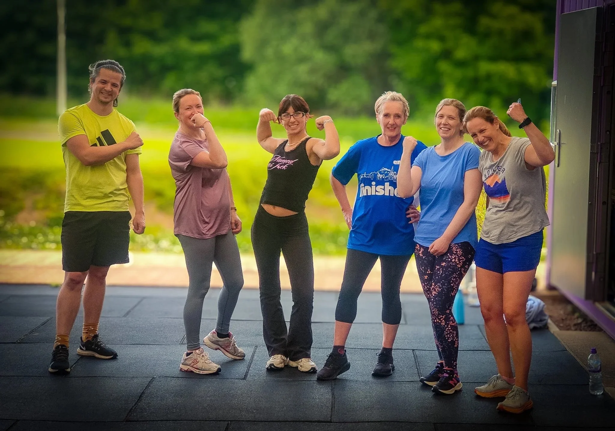 Happy Fitness class smiling and jokingly flexing muscles