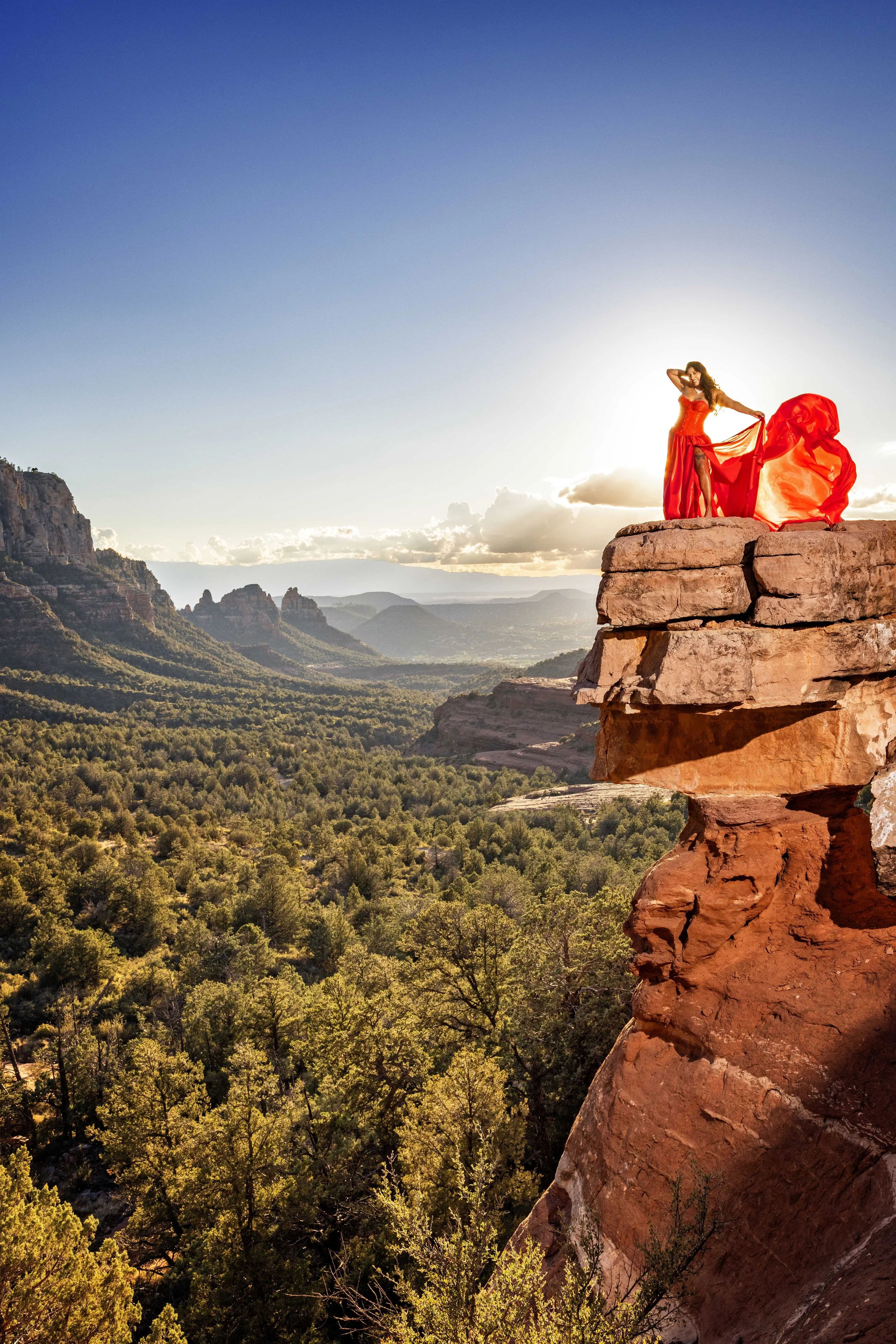 powerful picture lady in a ed flying dress high on the rocks at Sedona