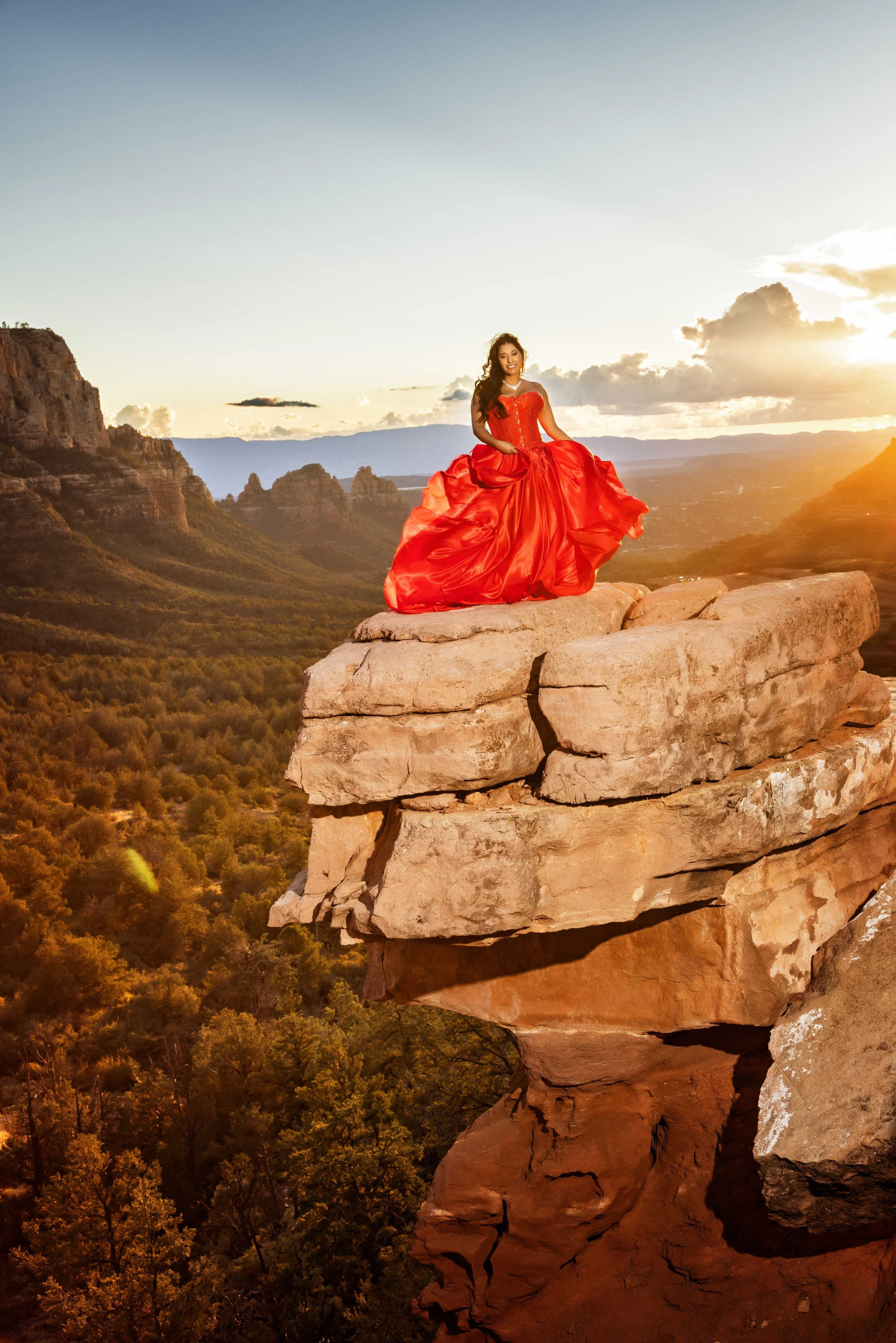 portrait of a lady in red flying dress dancing on the rocks 