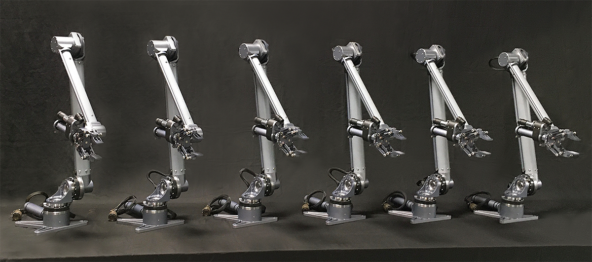 Six identical robotic arms with multiple joints, mounted on black bases, arranged in a row against a dark background.