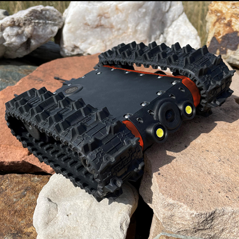 A rugged MicroTraxx inspection robot with tank-like tracks and a camera system, positioned outdoors on rocks.