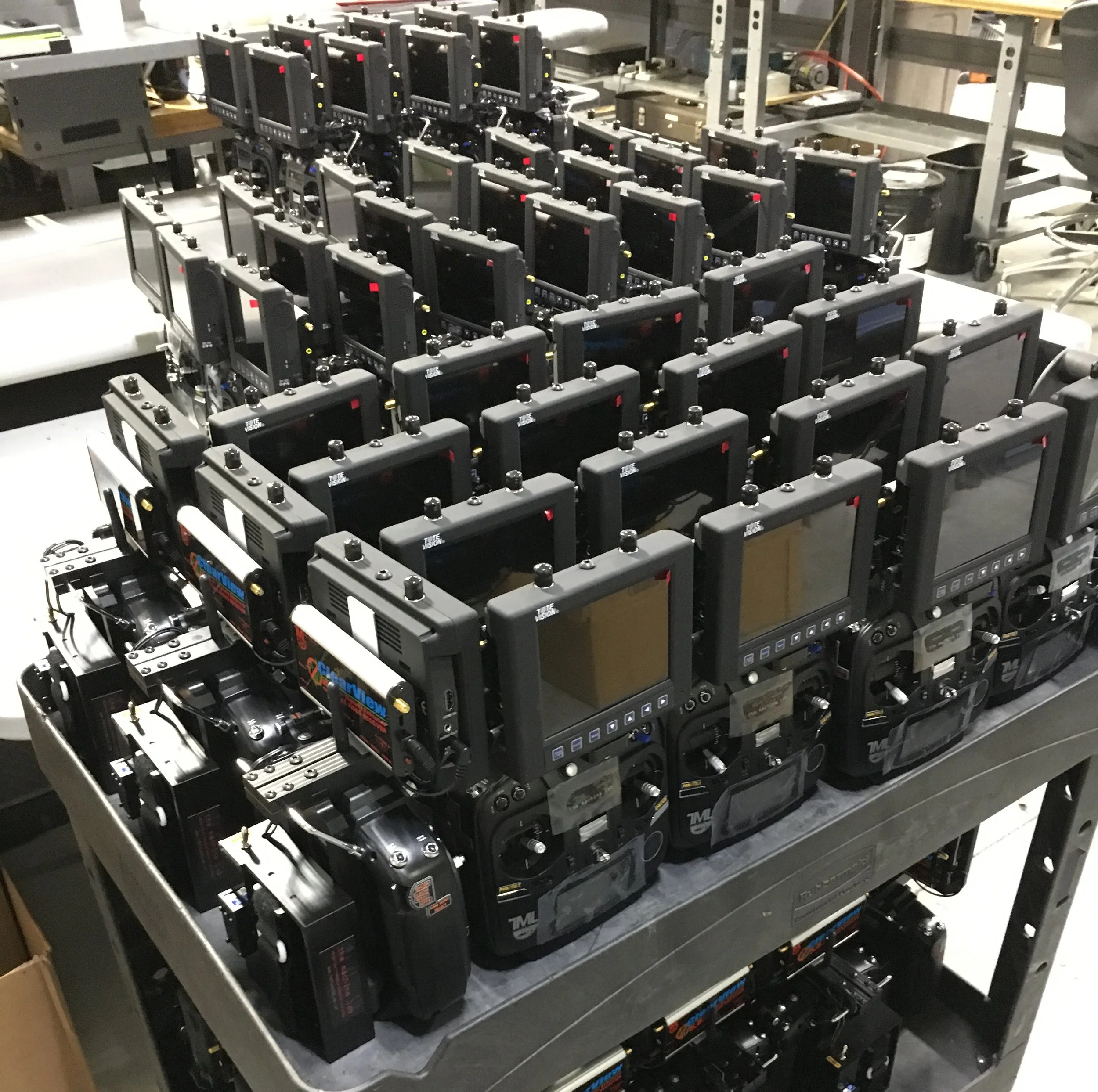 A large metal rack filled with multiple robot controllers, arranged in rows.