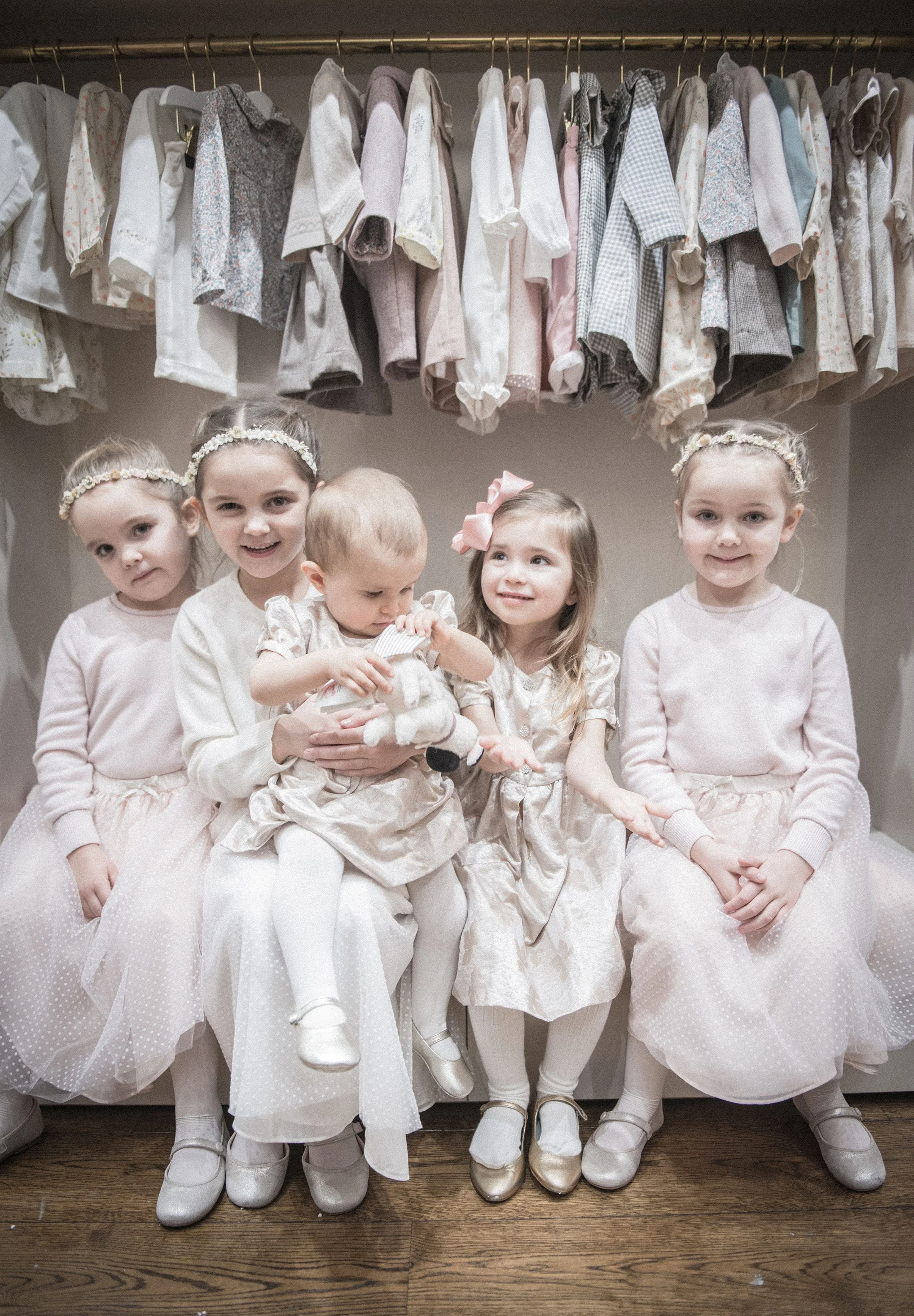 Five young girls sitting on a bench, at Marie Chantal  flagship store in Lonodn