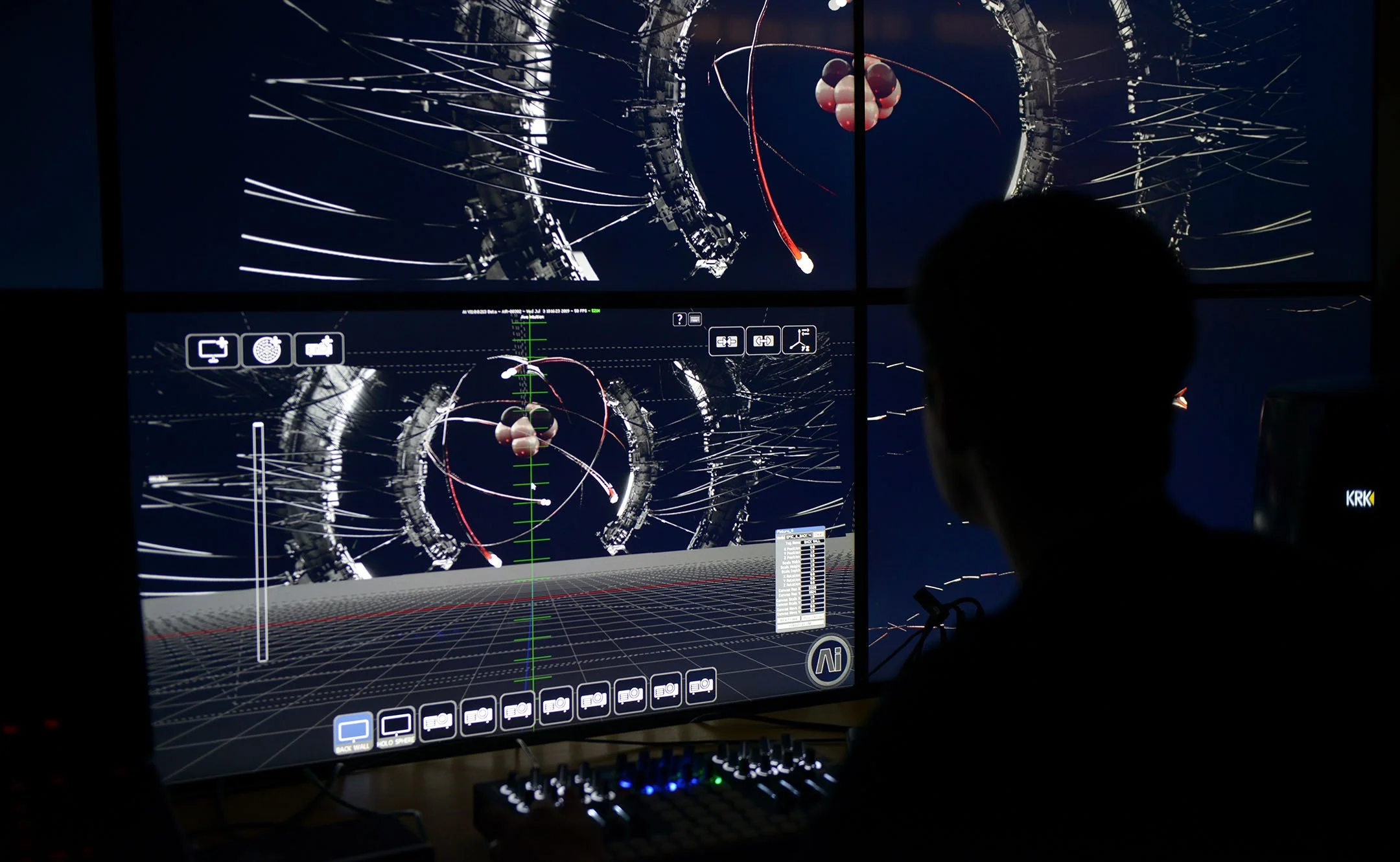 A person operating a computer with multiple screens displaying space simulation graphics, including planets, orbits, and spacecraft in a dark room.