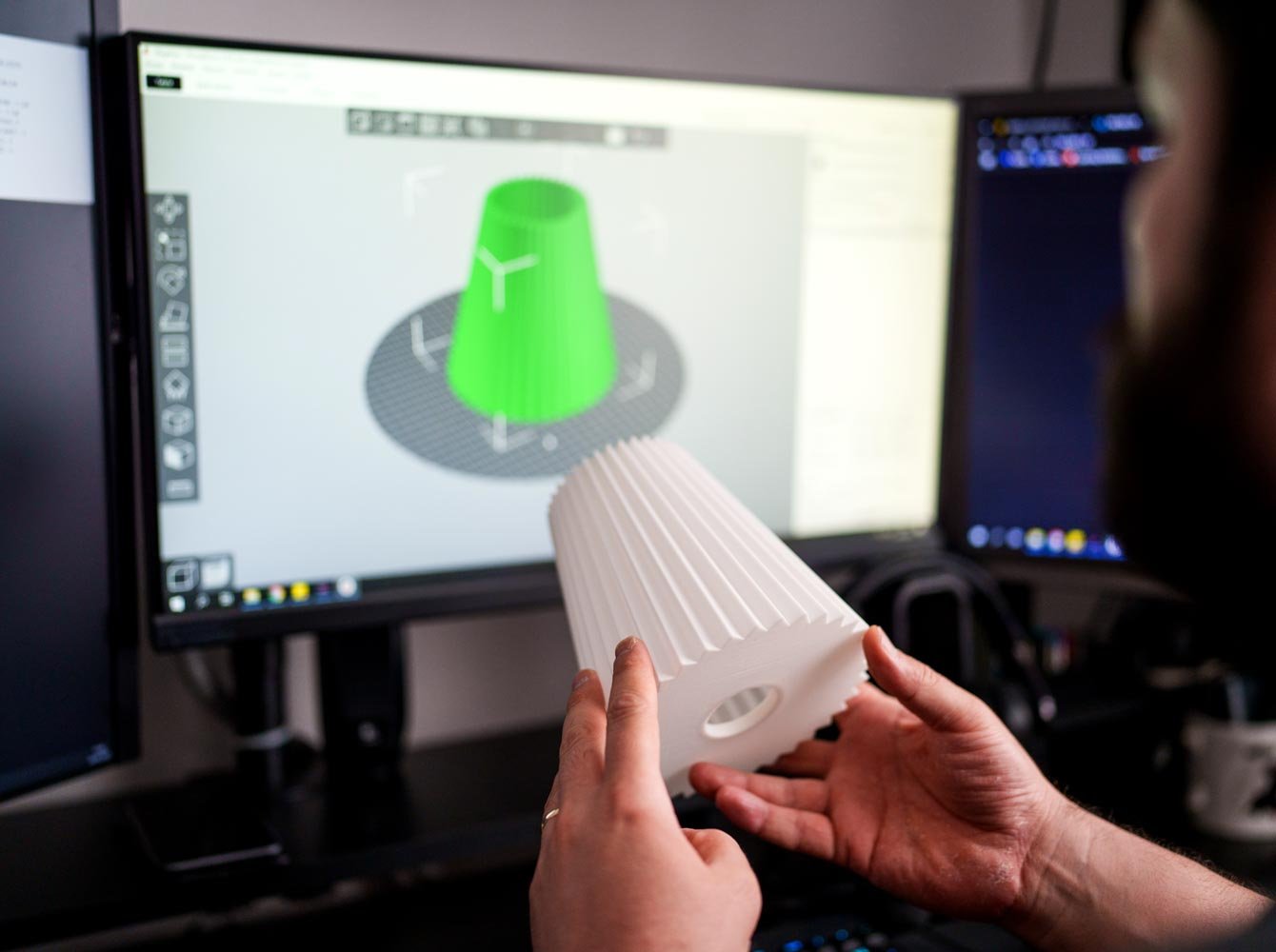 Suunnittelija mallintamassa kädessään olevaa 3D-esinettä.