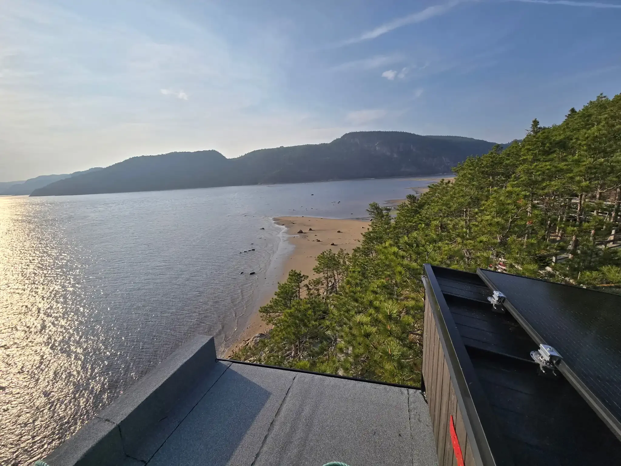 Rooftop solar panels overlooking a mountain lake