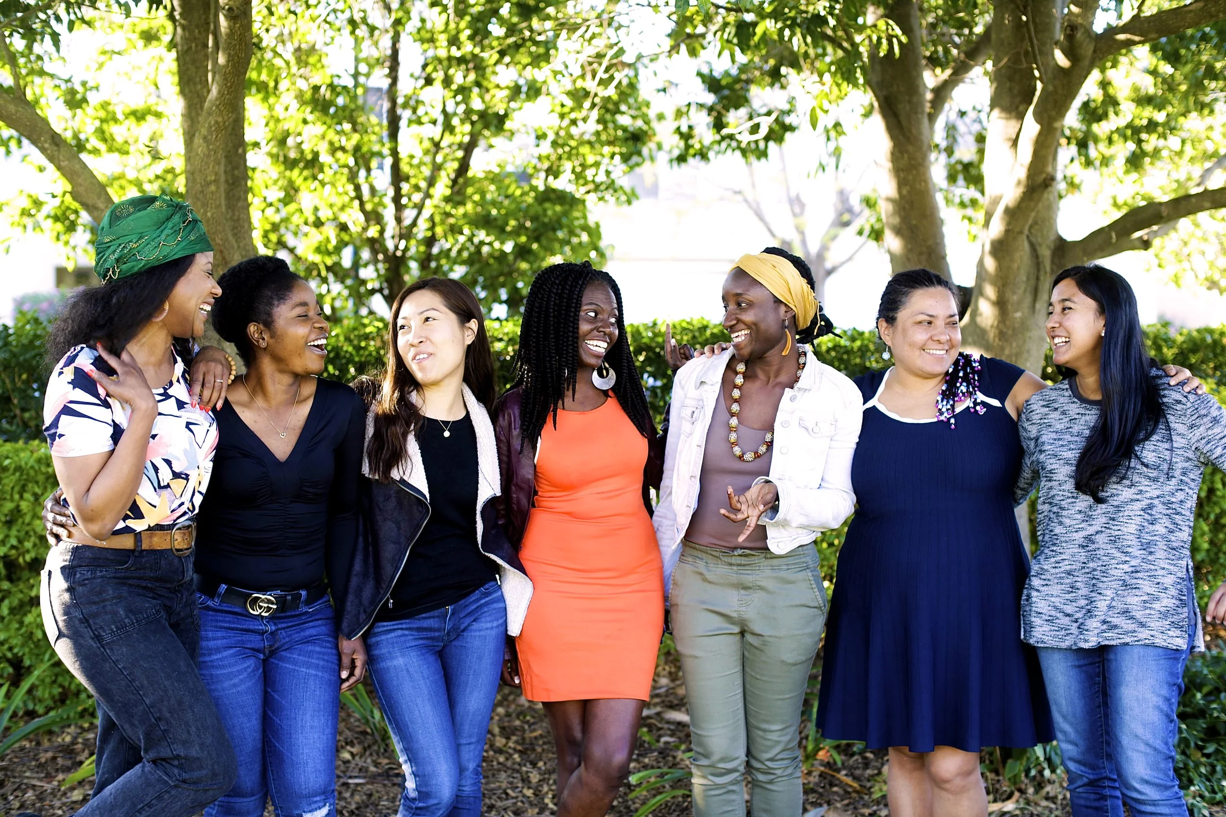 Group of women surrounding Hawa, standing side by side in a park