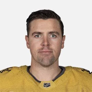 Photo of a man with dark hair and blue eyes wearing a yellow sports jersey.