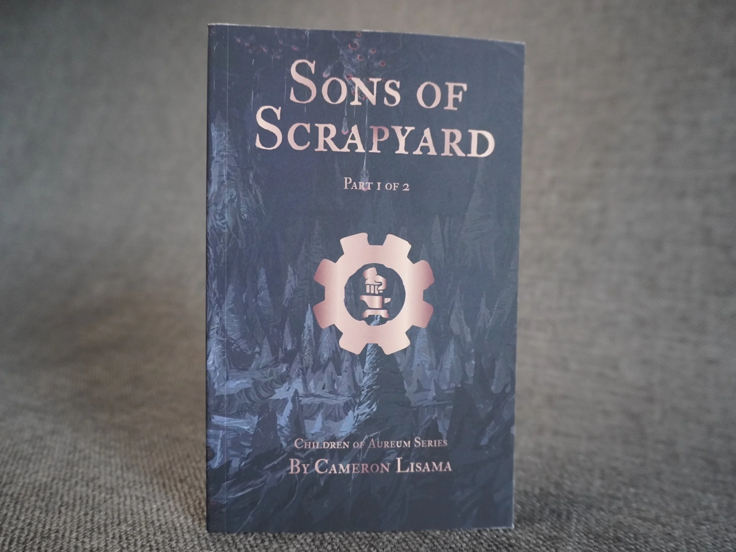 This is a product photo for the science fantasy action novel series, Sons of Scrapyard part 1 pocket edition, by Cameron Lisama.