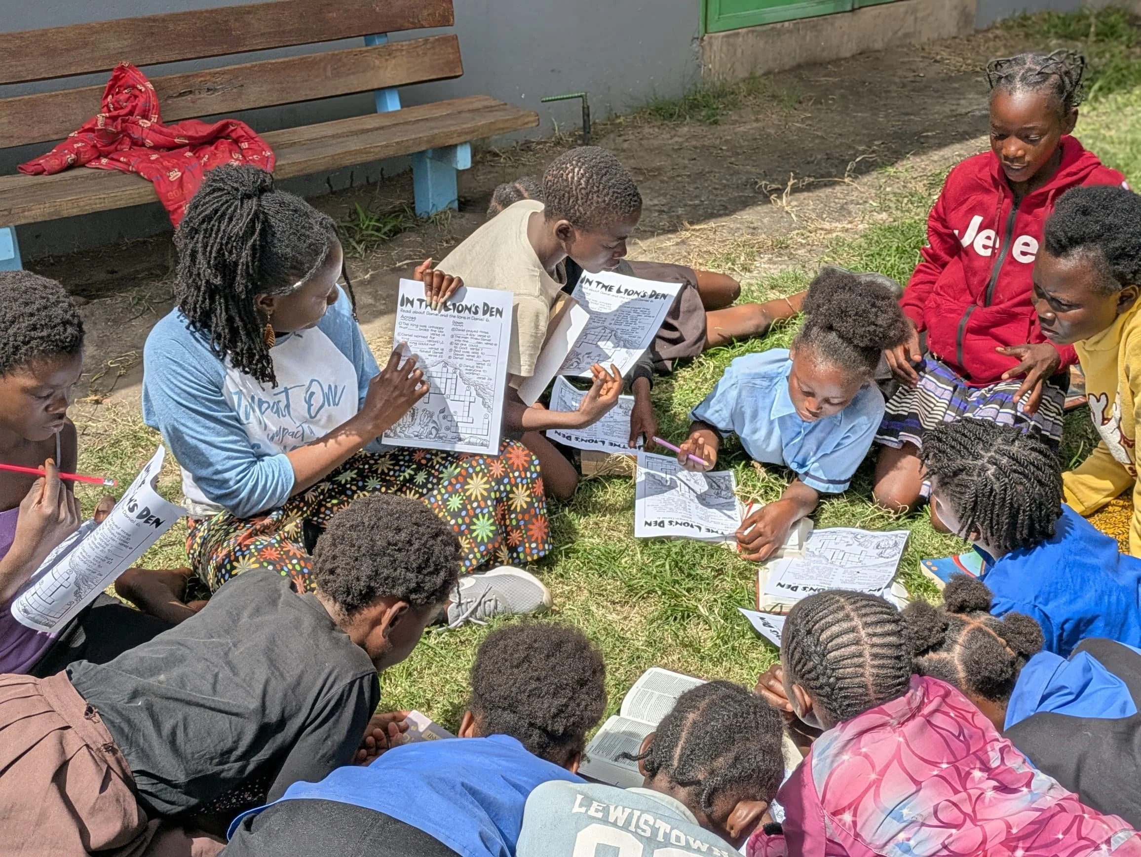 Impact One staff plays a Bible cross-word puzzle with a group of kids
