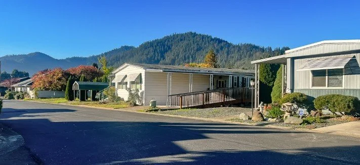 Residential houses with mountain backdrop and clear blue sky.