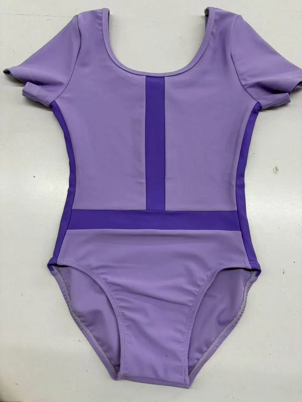 Purple athletic bodysuit with darker purple trim and a vertical stripe down the center.
