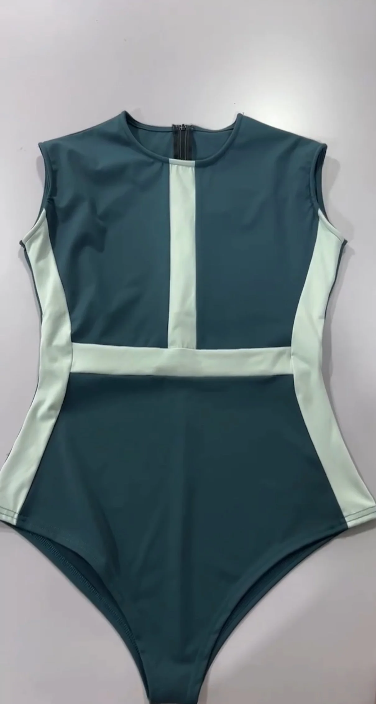 Green sleeveless body suit with white vertical and horizontal color blocks