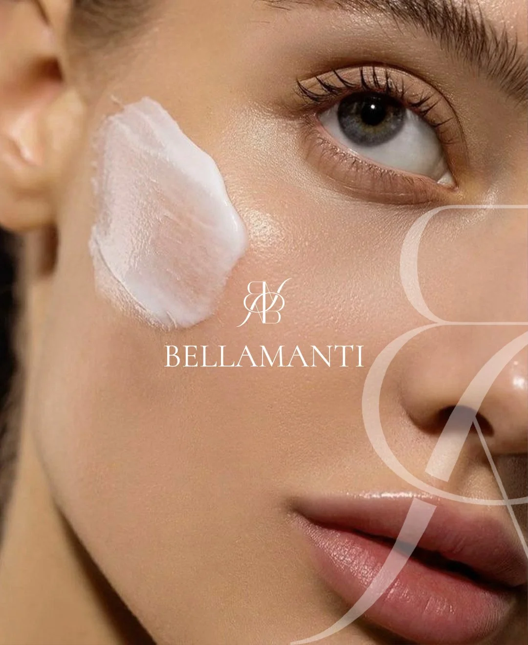 Close-up of a woman's face with a dollop of white cream on her cheek, part of the brand name Bellamenti visible over her face.