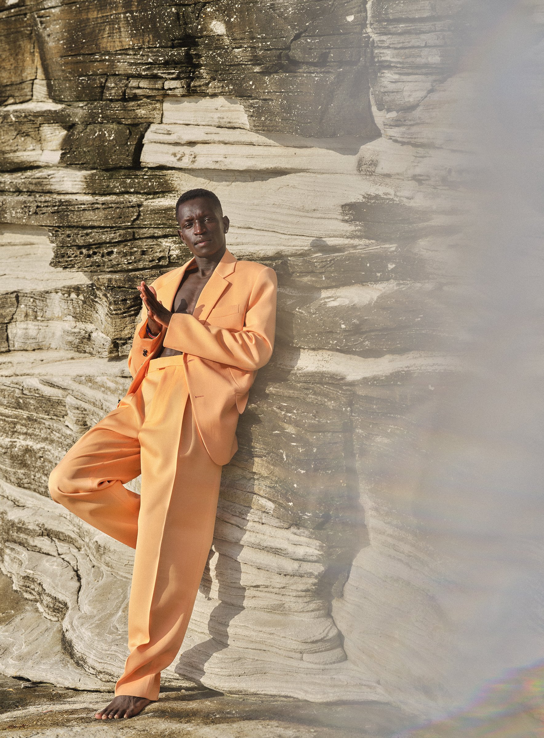 Olympic athlete Peter Bol photographed for Esquire Magazine on location at Clovelly Beach, Sydney, a natural light portrait shot against cliffs.