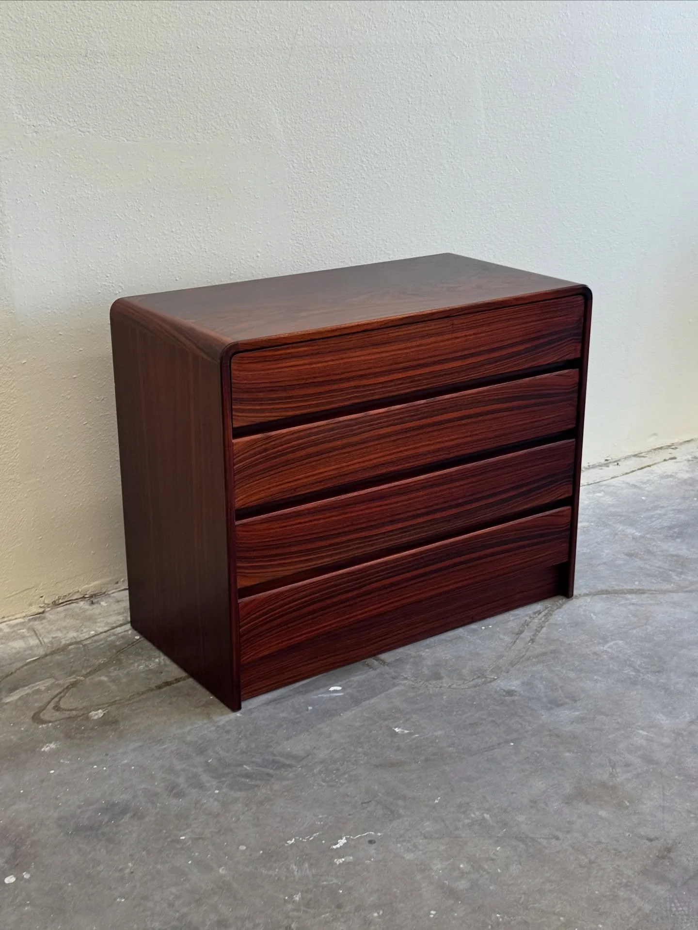 Danish dresser crafted from exquisite Brazilian rosewood

This mid-century modern piece, dating back to the 1960s, features a sleek, minimalist design with four spacious drawers, showcasing the rich, distinctive grain and deep reddish-brown tones cha