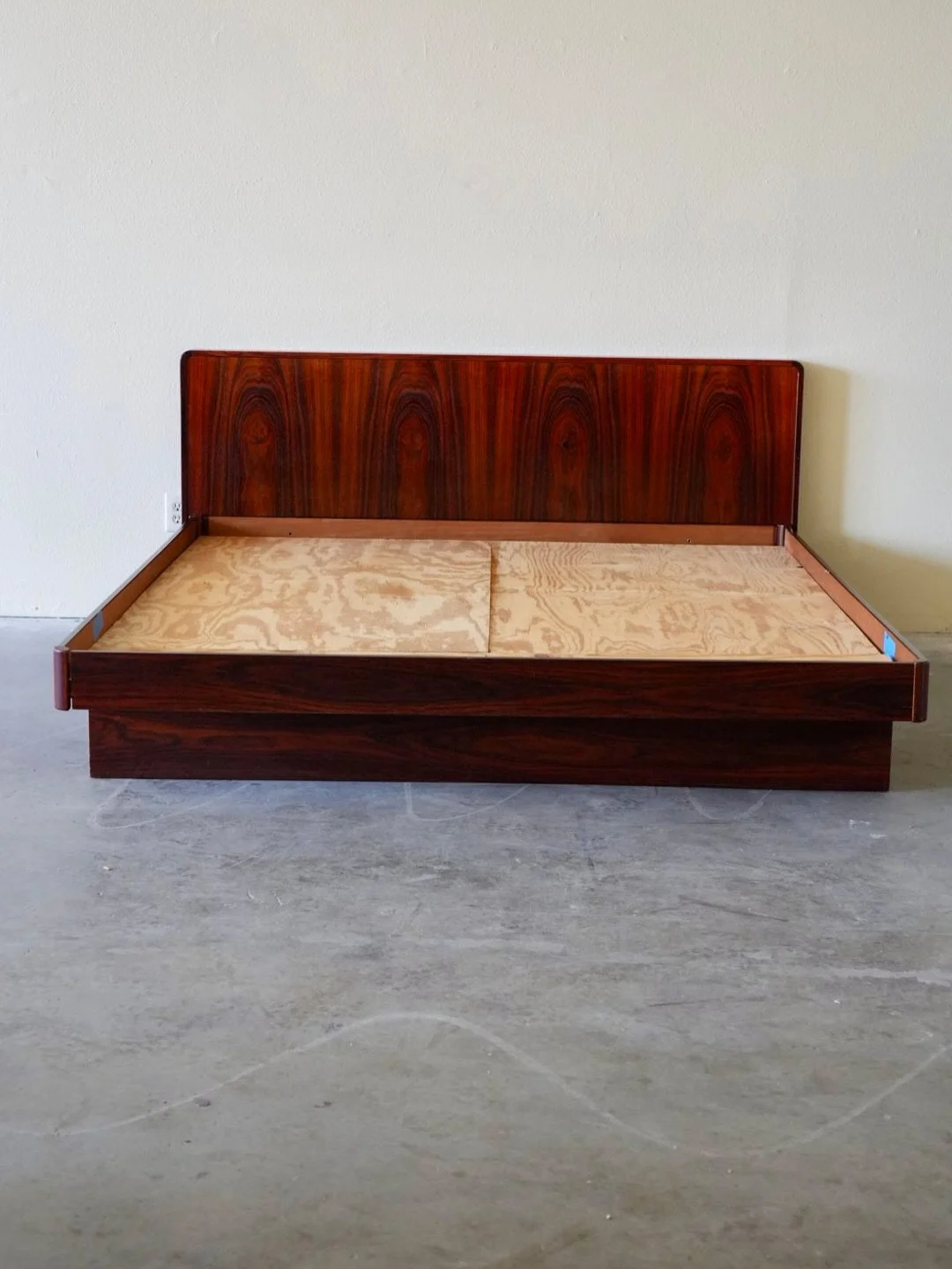 Rare California King Size Platform Bed made in Denmark. This is a true masterpiece of Danish MCM design! 

This bed is crafted from richly grained Rosewood, featuring a sophisticated, low-profile design. 

The bed includes a storage solution: one dee