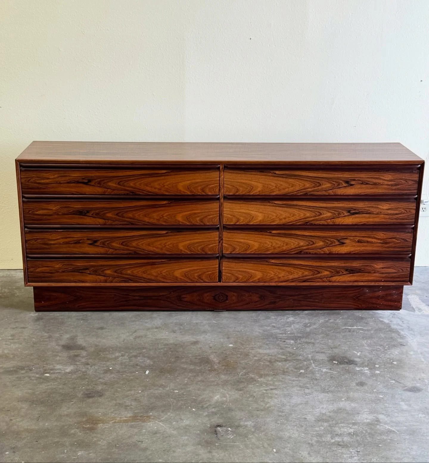 A true Scandinavian masterpiece. This vintage Westnofa rosewood lowboy dresser is all about craftsmanship and grain. 

Featuring 8 smooth-glide drawers and dramatic book-matched Brazilian rosewood, it brings warm MCM character into any space. Made in