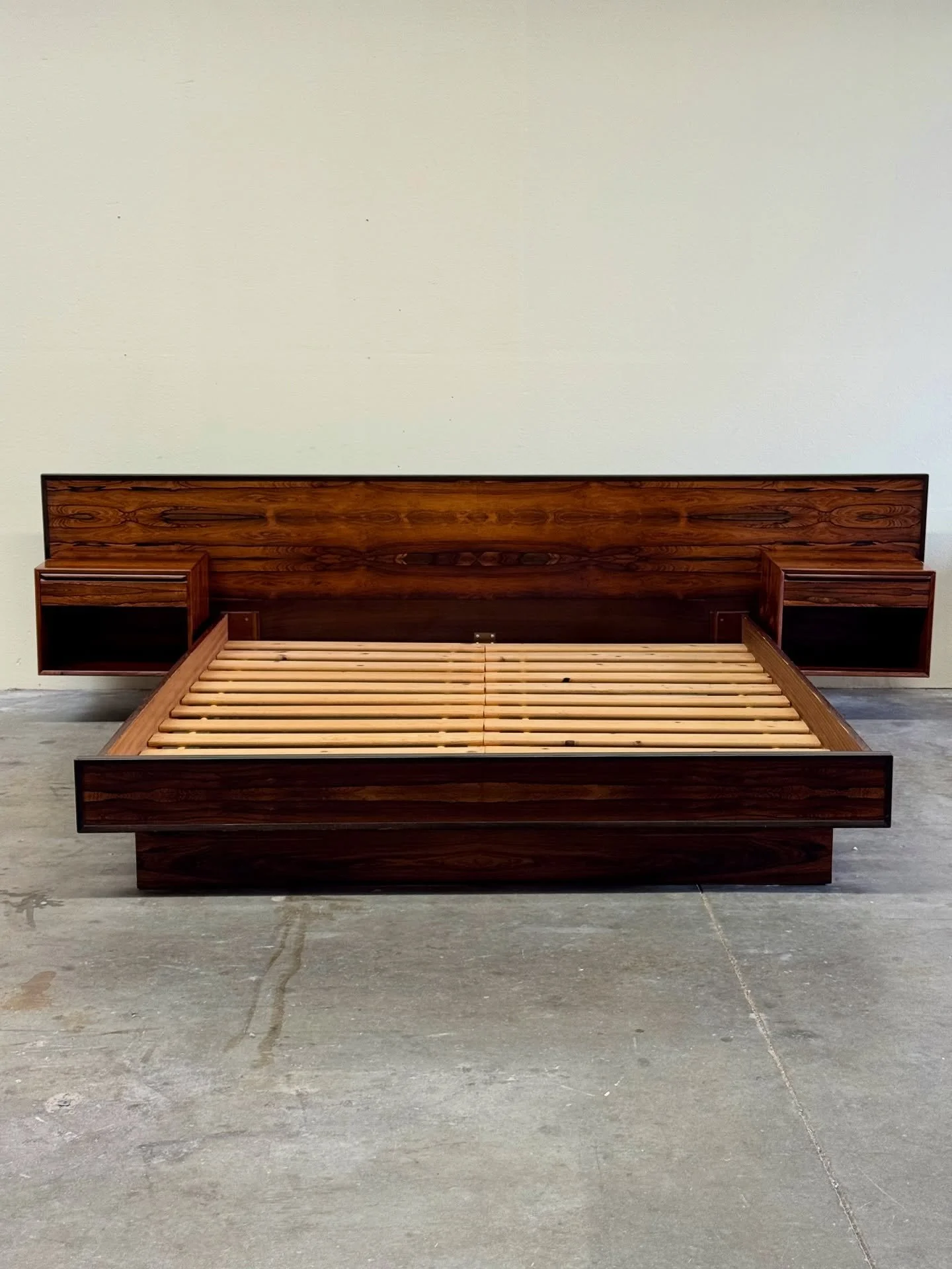 A show-stopping centerpiece 🤎
This Westnofa California King bed includes a dramatic rosewood headboard with two floating nightstands, each with drawer + open shelf storage. The book-matched grain across the full width is absolutely breathtaking.

A 