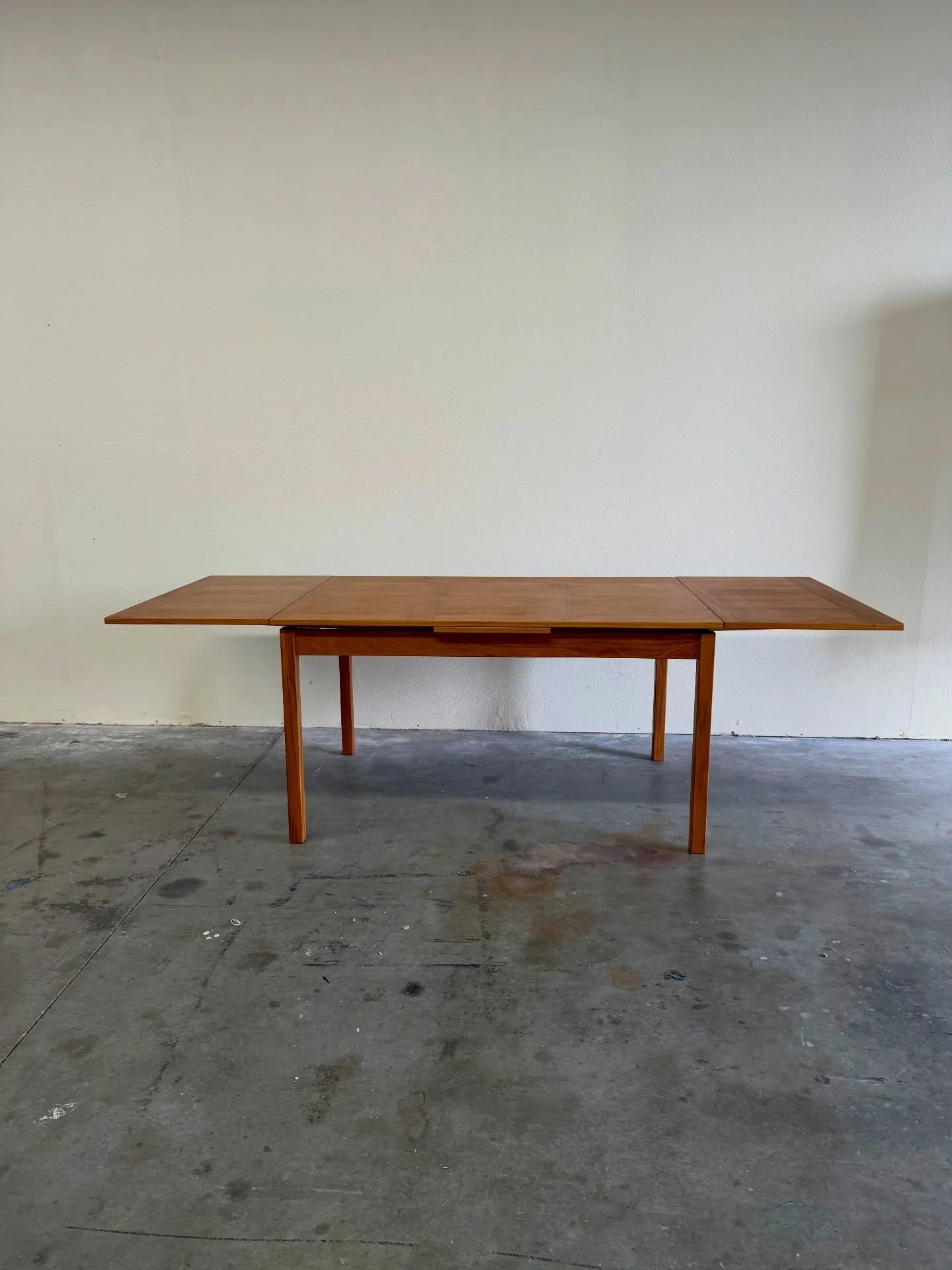 Authentic Danish extendable dining table crafted in solid teak by VSM, Denmark. A beautiful example of classic Scandinavian modern design featuring clean lines, warm teak tones, and elegant tapered legs.

The table includes a smooth extension mechani