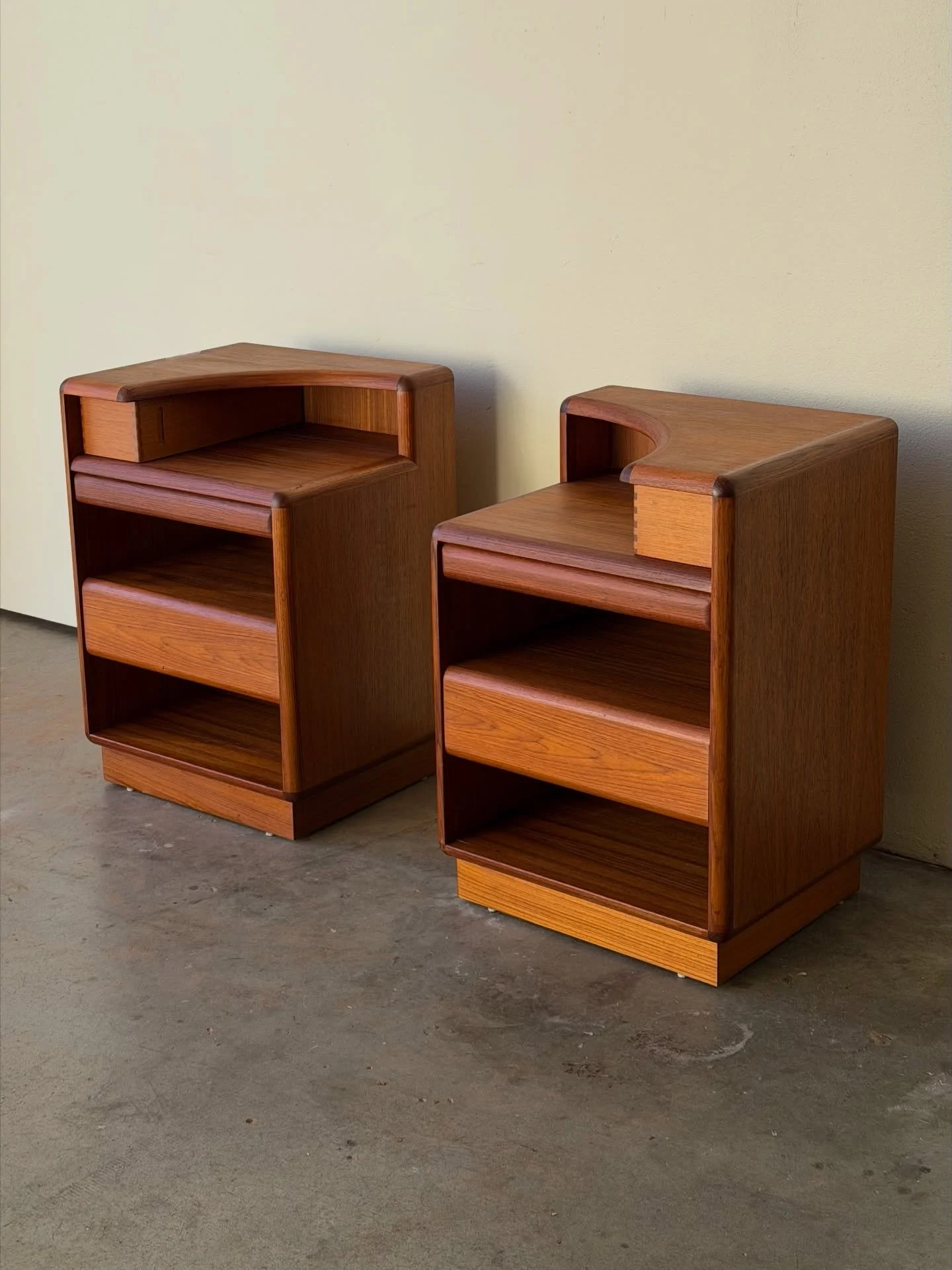 Elegant pair of Danish teak nightstands by Brouer, crafted in Denmark in the 1960s. These sculptural bedside tables feature beautifully curved corner detailing, rich teak grain, and a refined architectural silhouette that works effortlessly in both v