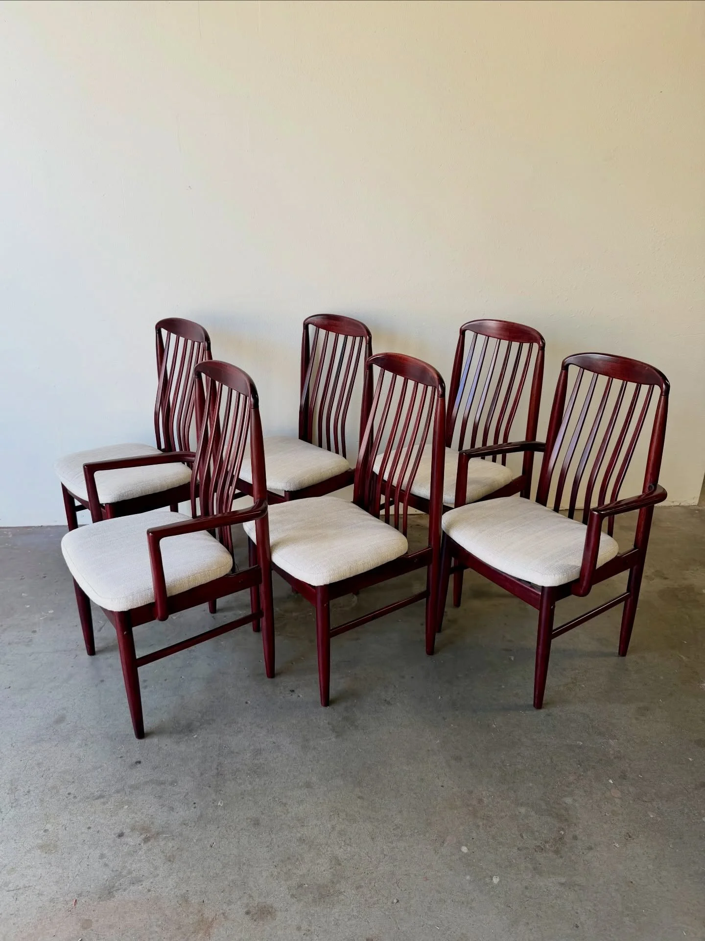 Set of six rosewood dining chairs by Benny Linden Design, showcasing refined Mid-Century Modern Scandinavian style. These chairs feature elegant vertical slat backs, gently curved frames, and a rich rosewood finish with warm tone and striking grain.
