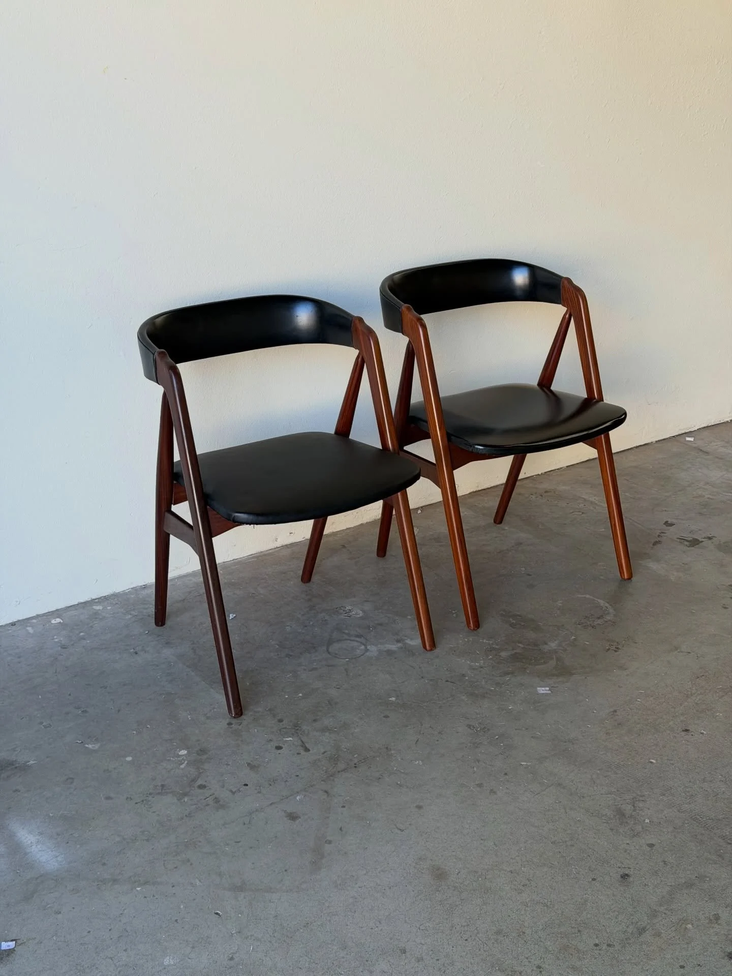 Danish teak &amp; black leather dining chairs by Thomas Harlev for Farstrup M&oslash;bler, Model 205, 1960s.

Solid teak sculptural frames with original black leather seats and backs. The curved back design offers both lightness and comfort &mdash; a