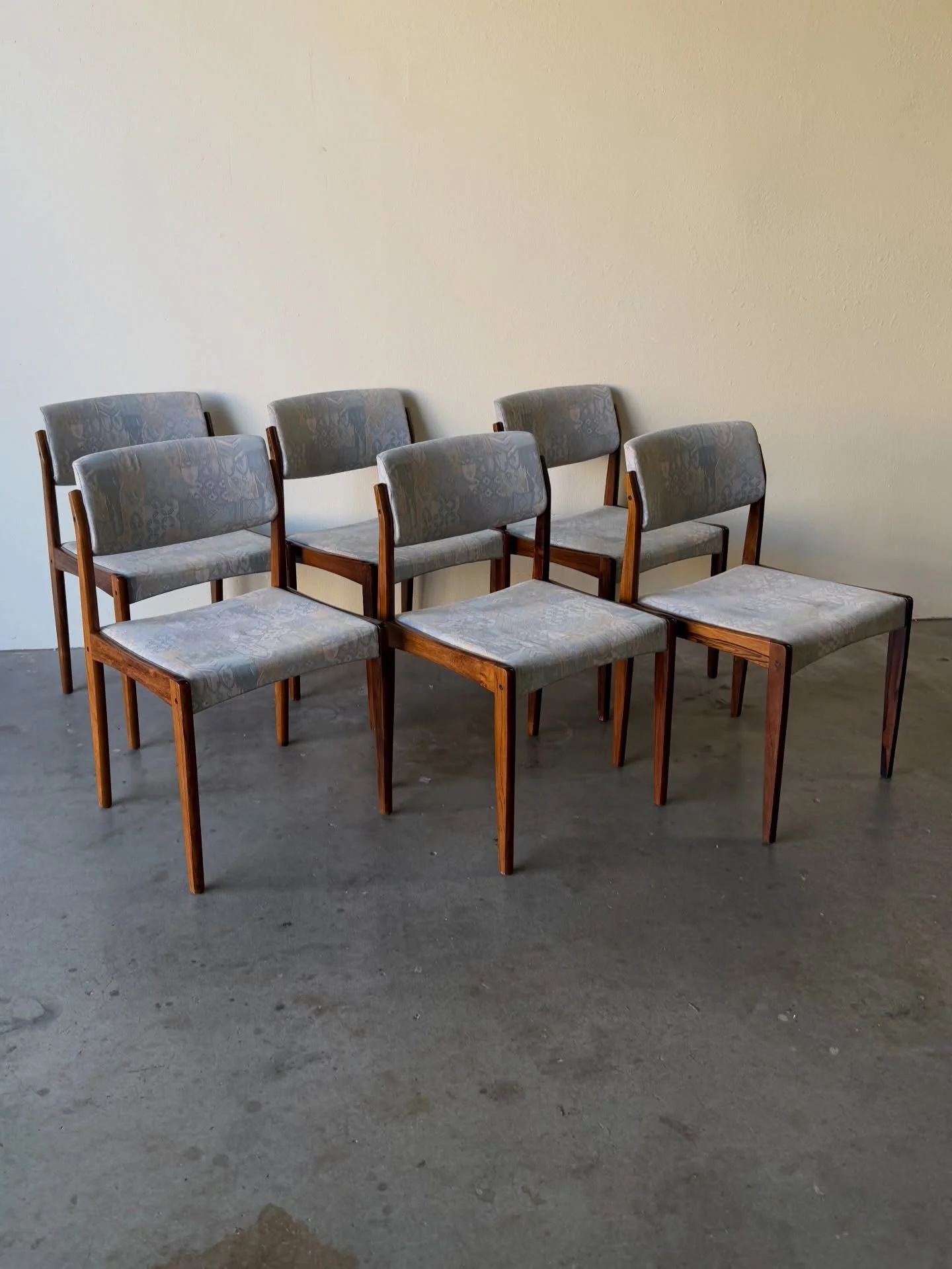 Elegant set of six Danish dining chairs by Bramin, crafted in richly grained rosewood.

Beautiful architectural lines, sculpted frames, and gently curved upholstered backs offer both comfort and balance. Upholstered in a subtle neutral fabric that pe